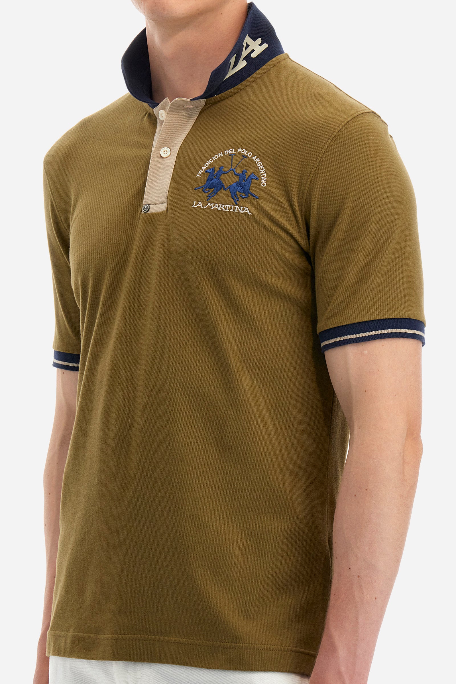Men's single-colour short-sleeved polo in elasticated cotton. Fastens with two contrasting buttons. Ribbed collar and armholes in different shades. The "La Martina" lettering can be found under the collar. A large logo is embroidered on the chest. The fit is slim. The model wears a size L. - Military Olive