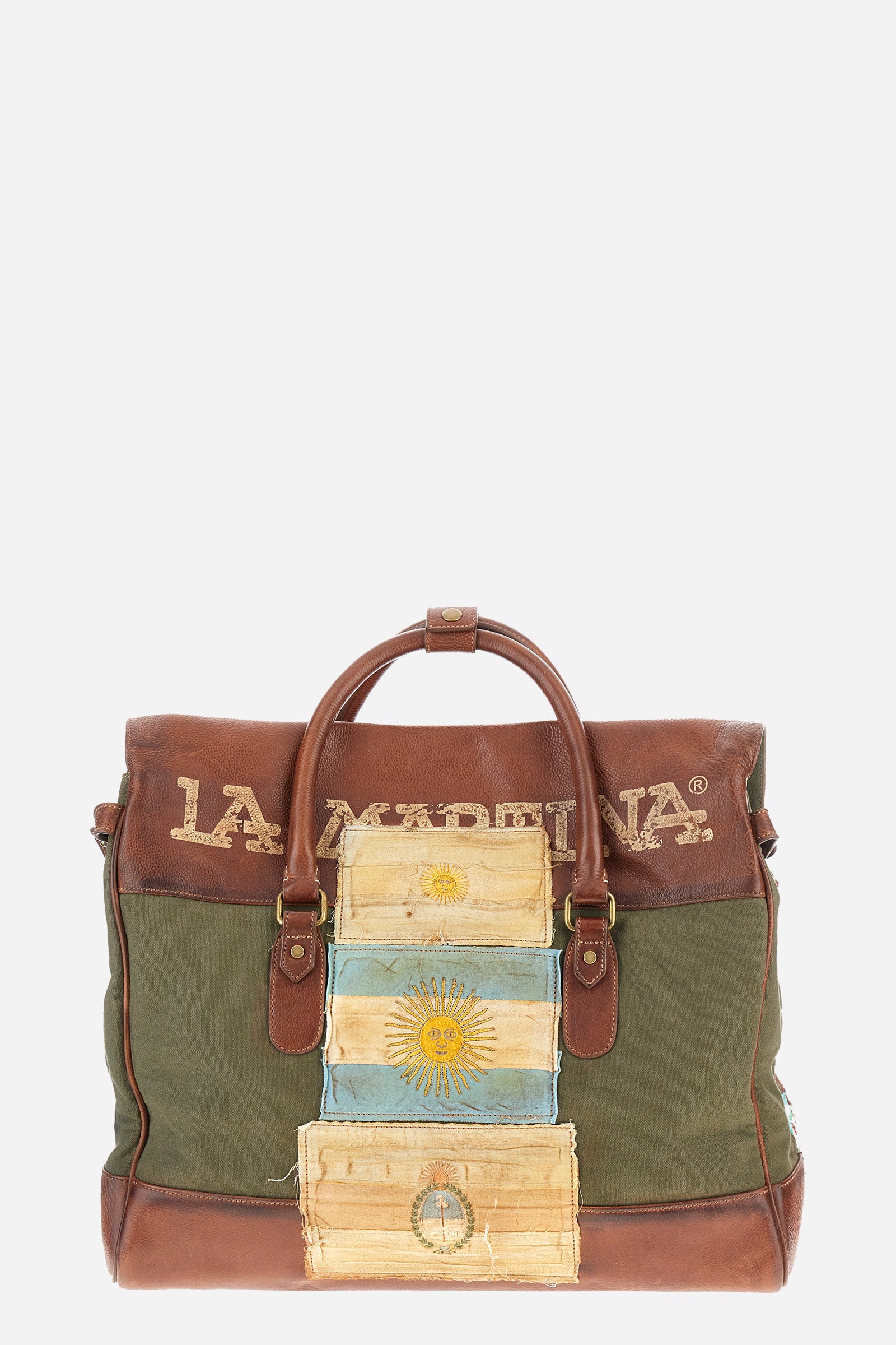 Unisex bicolor duffel bag made of 100% leather. Snap button closure. Equipped with two handles and a removable shoulder strap. Inside, there is a zippered pocket. Iconic design of the brand, embellished with writings, patches, and applied labels throughout the accessory. The La Martina logo is on the back. Dimensions (width x height x depth) 68x43x26 cm. - Military Olive