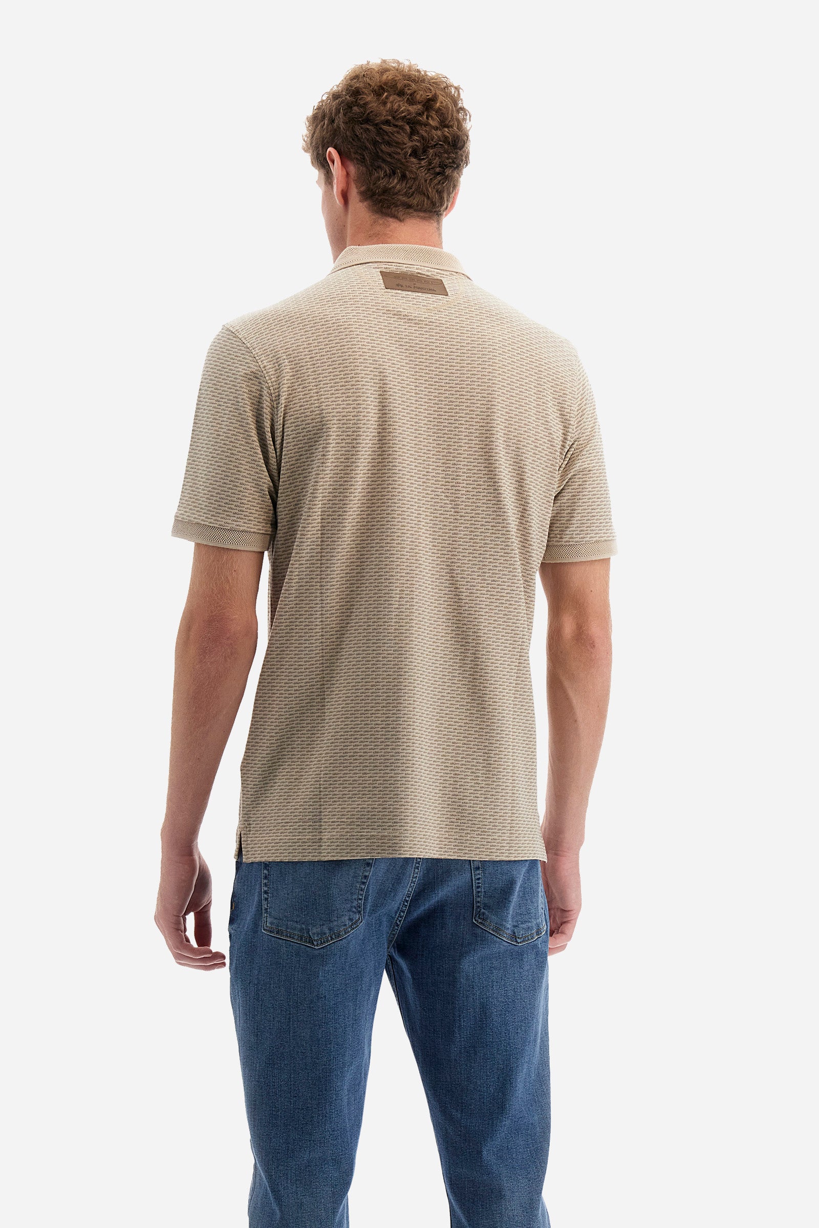 Single-colour men's polo shirt with short sleeves from the line in collaboration with Pagani. Made of stretch cotton. Two-button fastening. The collar and armholes feature a different texture. The garment features lettering throughout. A patch with the brand's name and logo and the word "Pagani" is applied on the back. The fit is regular. The model wears a size L. - RAINYDAY/FEATHERGRAY