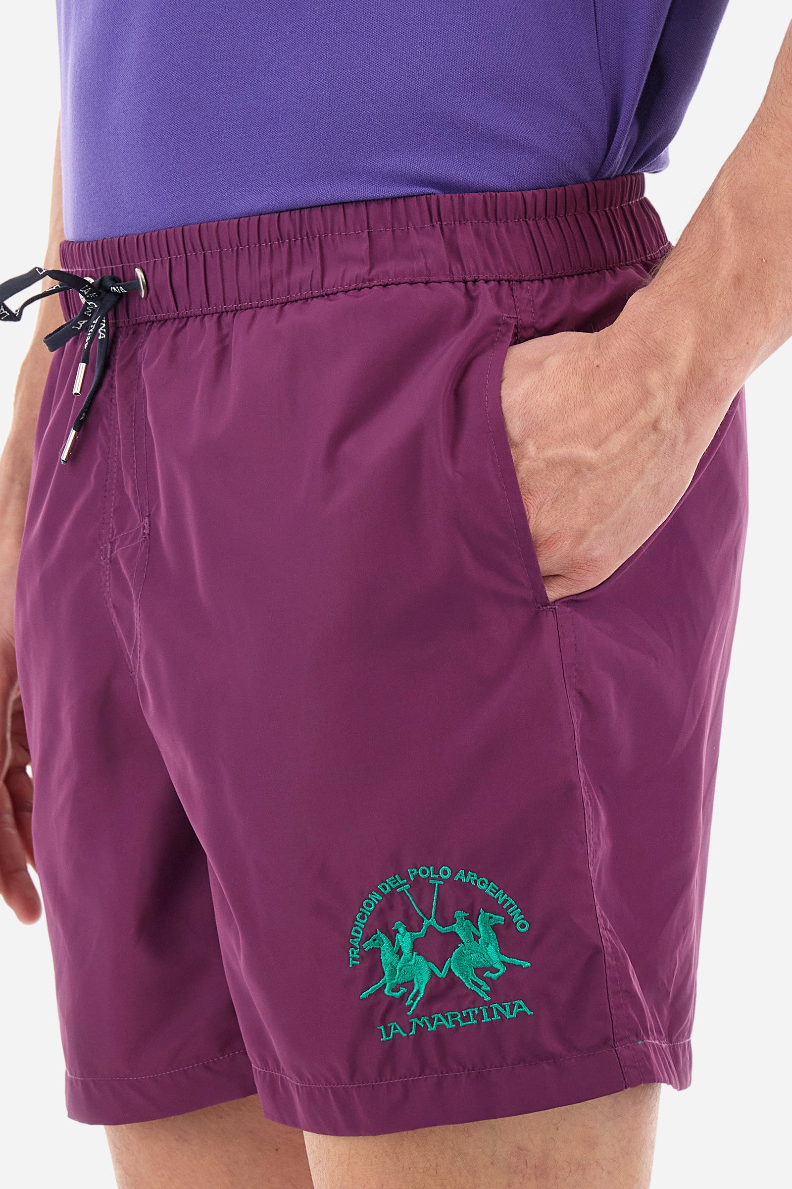 Single-colour men's swimming shorts, made of synthetic fabric. Featuring a drawstring and tie with "La Martina" lettering. Double welt pocket on the front. Closed pocket on the back. Mesh lining. Large logo embroidered on the front. The fit is regular. The model wears a size L. - Gloxinia