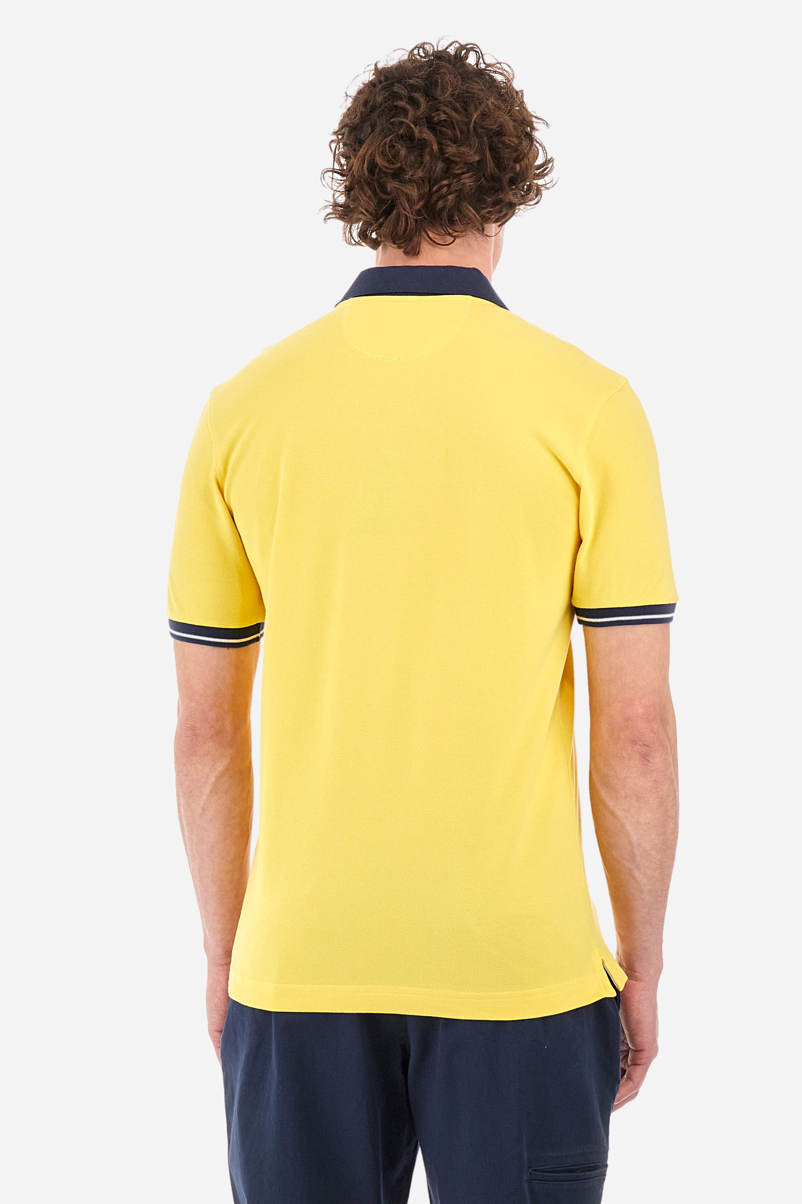 Men's single-colour short-sleeved polo in elasticated cotton. Fastens with two contrasting buttons. Ribbed collar and armholes in different shades. The "La Martina" lettering can be found under the collar. A large logo is embroidered on the chest. The fit is slim. The model wears a size L. - Aspen Gold