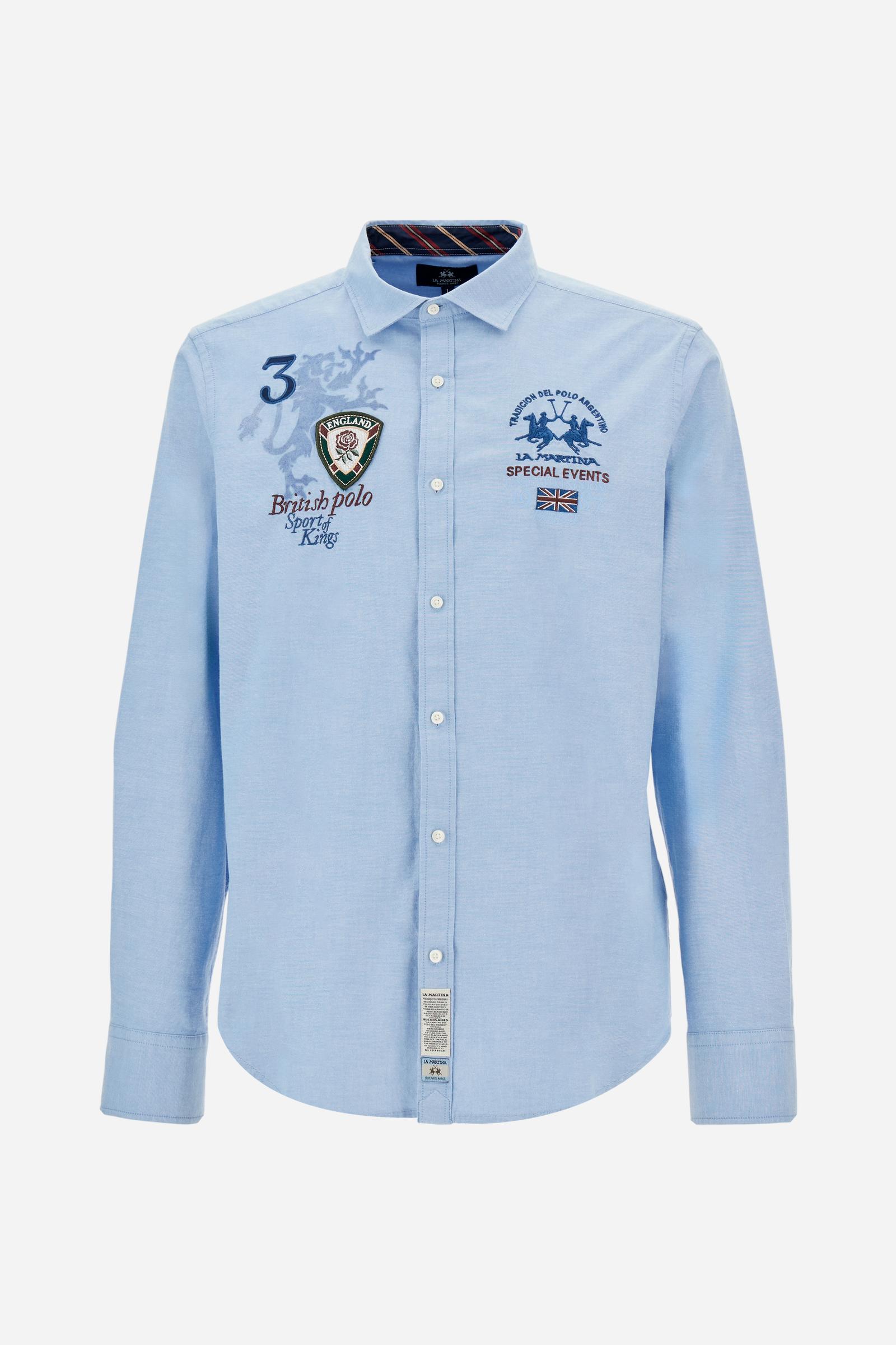 Classic men's long-sleeved shirt in stretch cotton Oxford, solid colour. Finished with a French collar and interior regimental-pattern fabric details. Chest features multicolour prints and embroideries inspired by British Polo, including the large team logo embroidered in contrast. Regular fit ensuring comfort and enhancing any physique. Model wears size L. - Cornflower blue