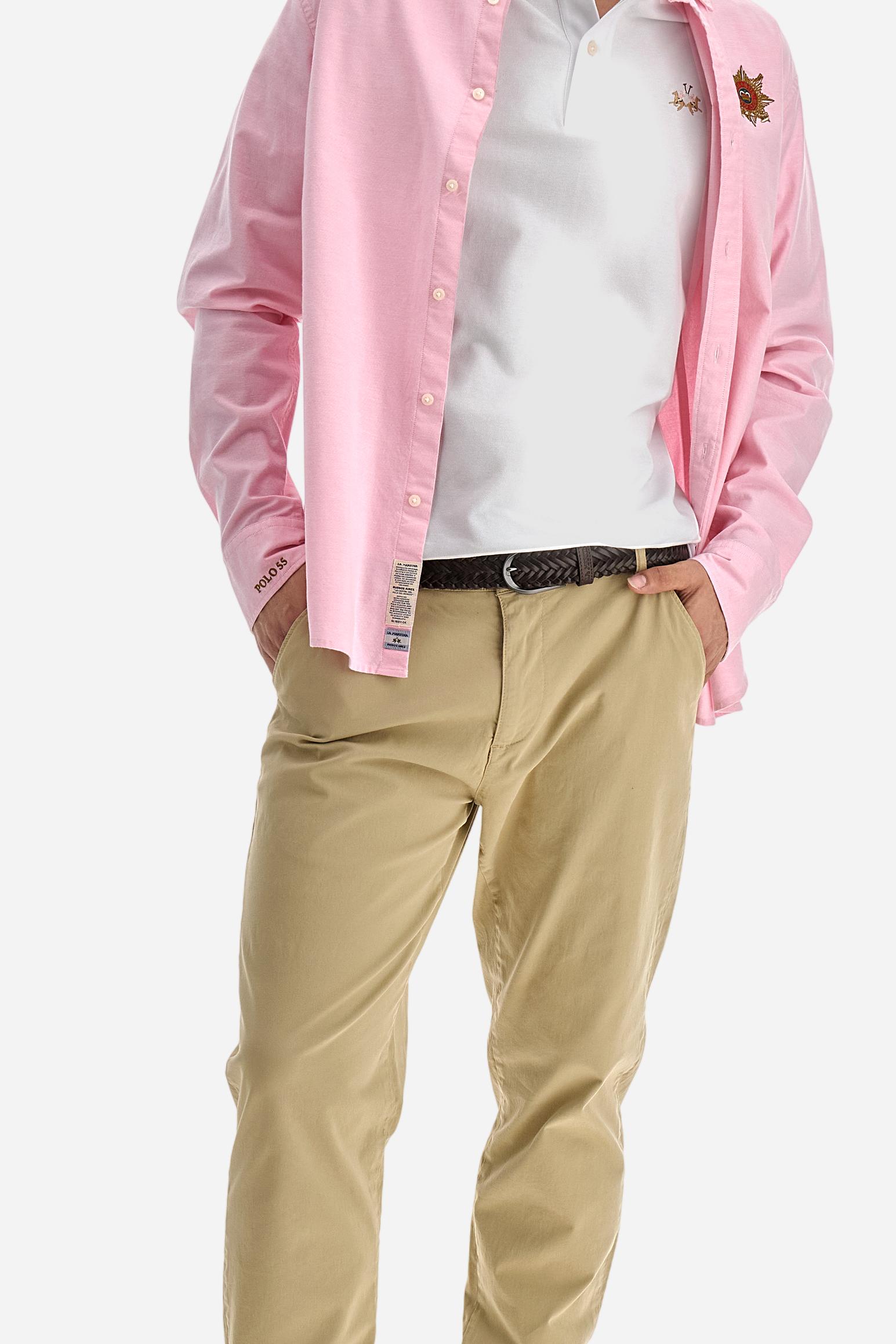 Short-sleeved, single-colour men's polo shirt made of stretch cotton piqué. Fastens with two buttons. The collar and cuffs are ribbed, and there is a colour-contrasting trim at the bottom of the collar. Inside the collar there is a grosgrain ribbon of a different shade. The logo is embroidered on the chest in a contrasting colour. The fit is slim. The model is wearing a size L. - Optic White