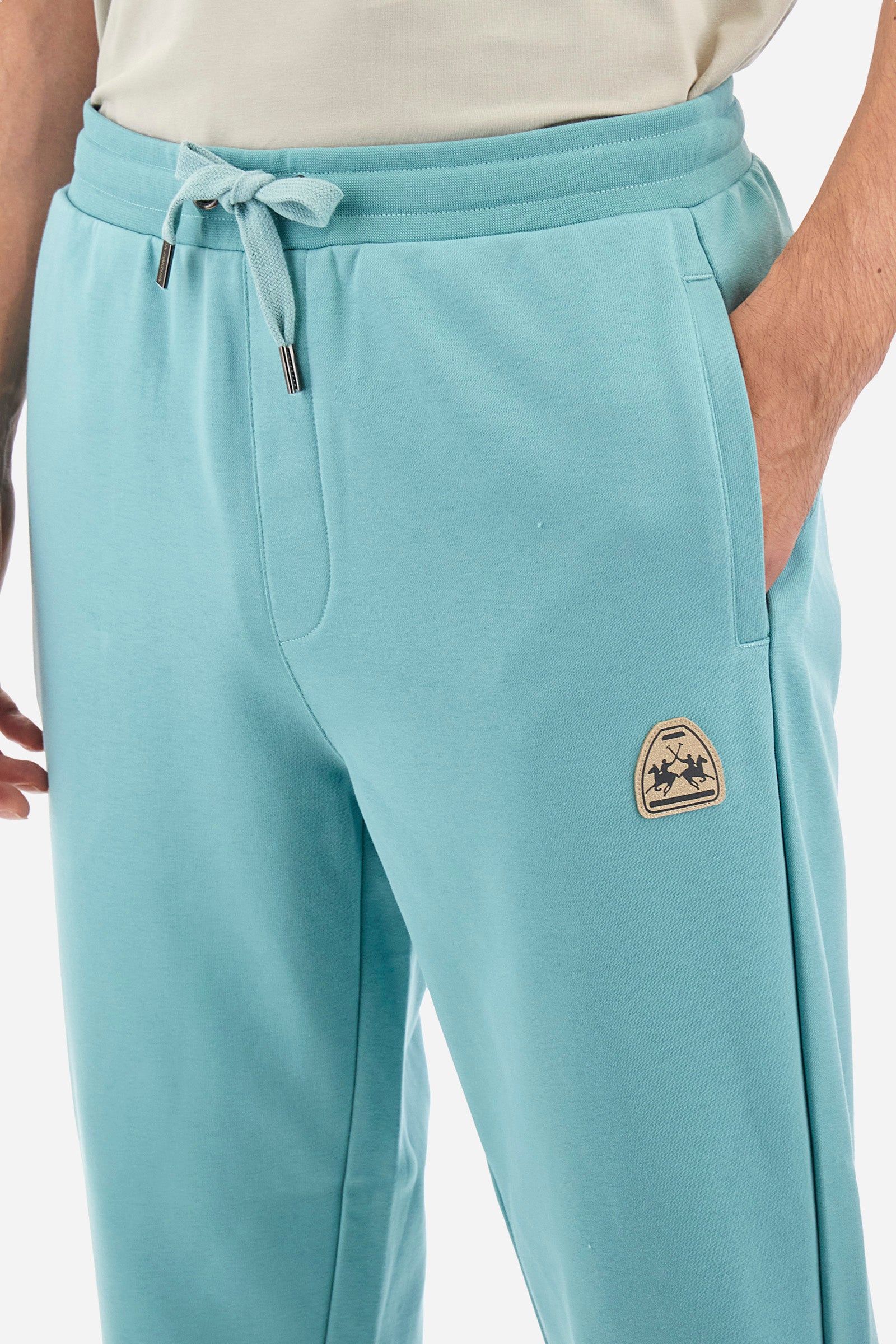Men's single-colour jogging bottoms in a cotton sweat fabric from the Polo Academy line. With a drawstring waist and double front pocket. Another pocket is present on the back. The logo is present on a patch applied under one of the front pockets. The fit is regular. The model wears a size L. - Aquifer