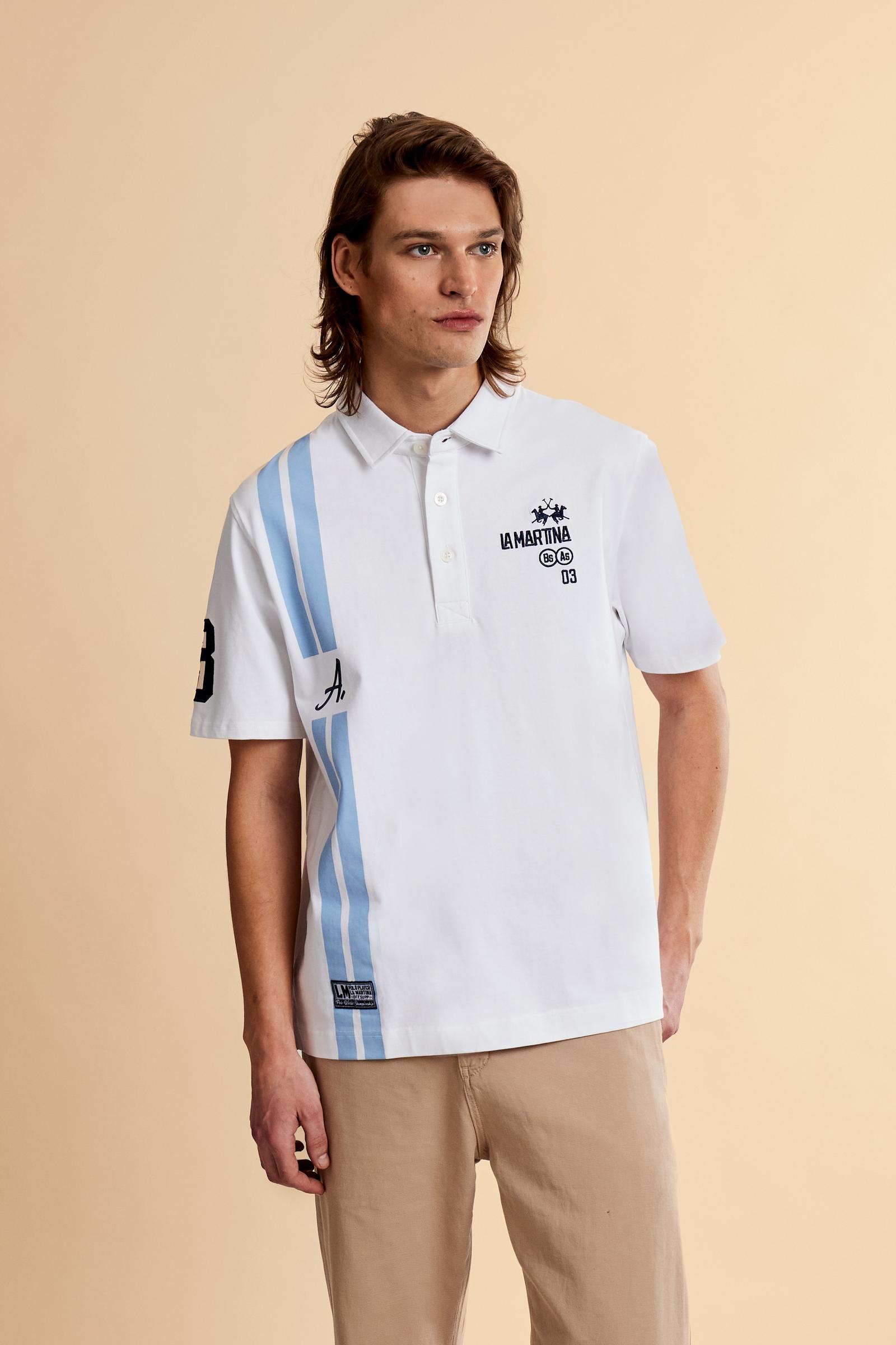 Men’s heavy cotton jersey polo with three-button placket and striped details. Celebratory maxi graphic and bold lettering. - Optic White