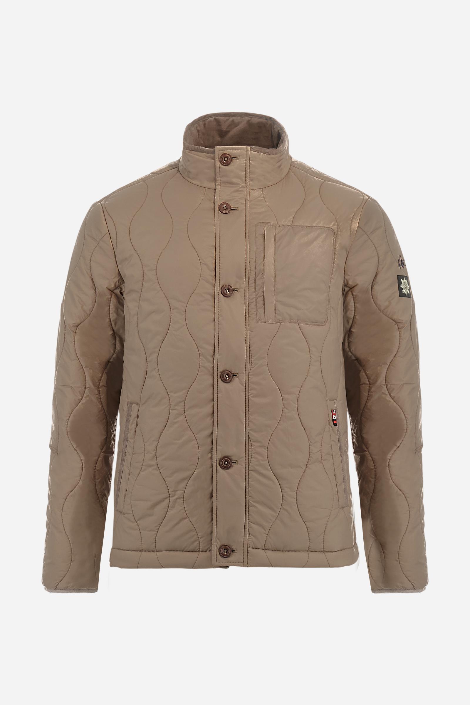 Men’s quilted nylon husky jacket with high collar. Front closure with customized zip and large faux-leather buttons. Interior lined with striped bicolor polyester. Contrast details on the inside (pockets, profiles, back-neck tab). Clean design with chest pocket closed by zip and vertical side pockets. Adjustable back straps with metal snap buttons. Logo patches on the sleeves and multicolor embroidered lettering on the outer collar. Part of the Guards capsule. Regular fit. Model wears size L. - Moon Rock