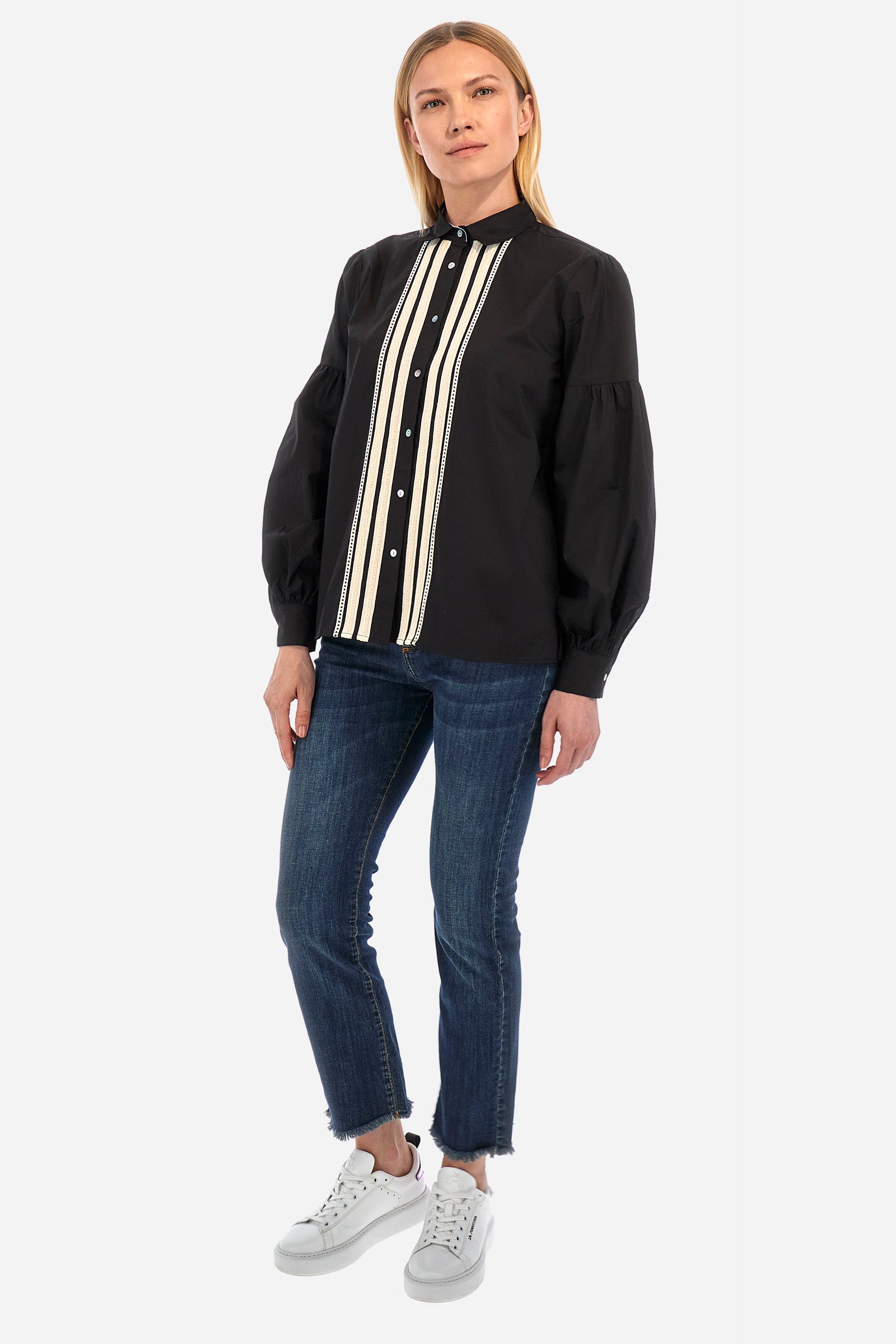 The Argentina women's shirt is made of solid-coloured stretch cotton, with an elegant regular fit. The design features a refined classic collar and button fastening with cable and openwork trims, giving the shirt a distinctive edge. The long sleeves, adorned at the top with a balloon effect, give the shirt a delicate and romantic look. Finally, the LM logo applied the sleeve completes the garment with a sophisticated and contemporary aesthetic. The model is 174 cm tall and wears a size 2. - Black