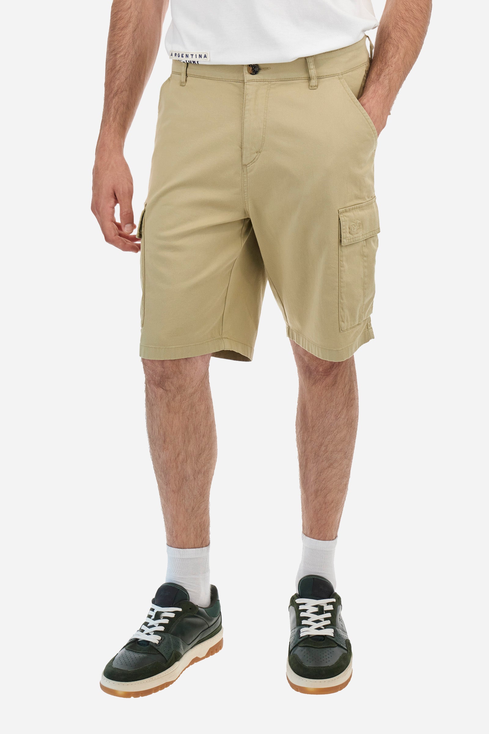 Men's single-colour Bermuda shorts in cotton twill. There are two American pockets, two cargo pockets and two back pockets. With belt loops. Zip and button fastening. The logo is embroidered tone-on-tone on the left cargo pocket. Regular fit. The model is wearing a size 33. - Twill