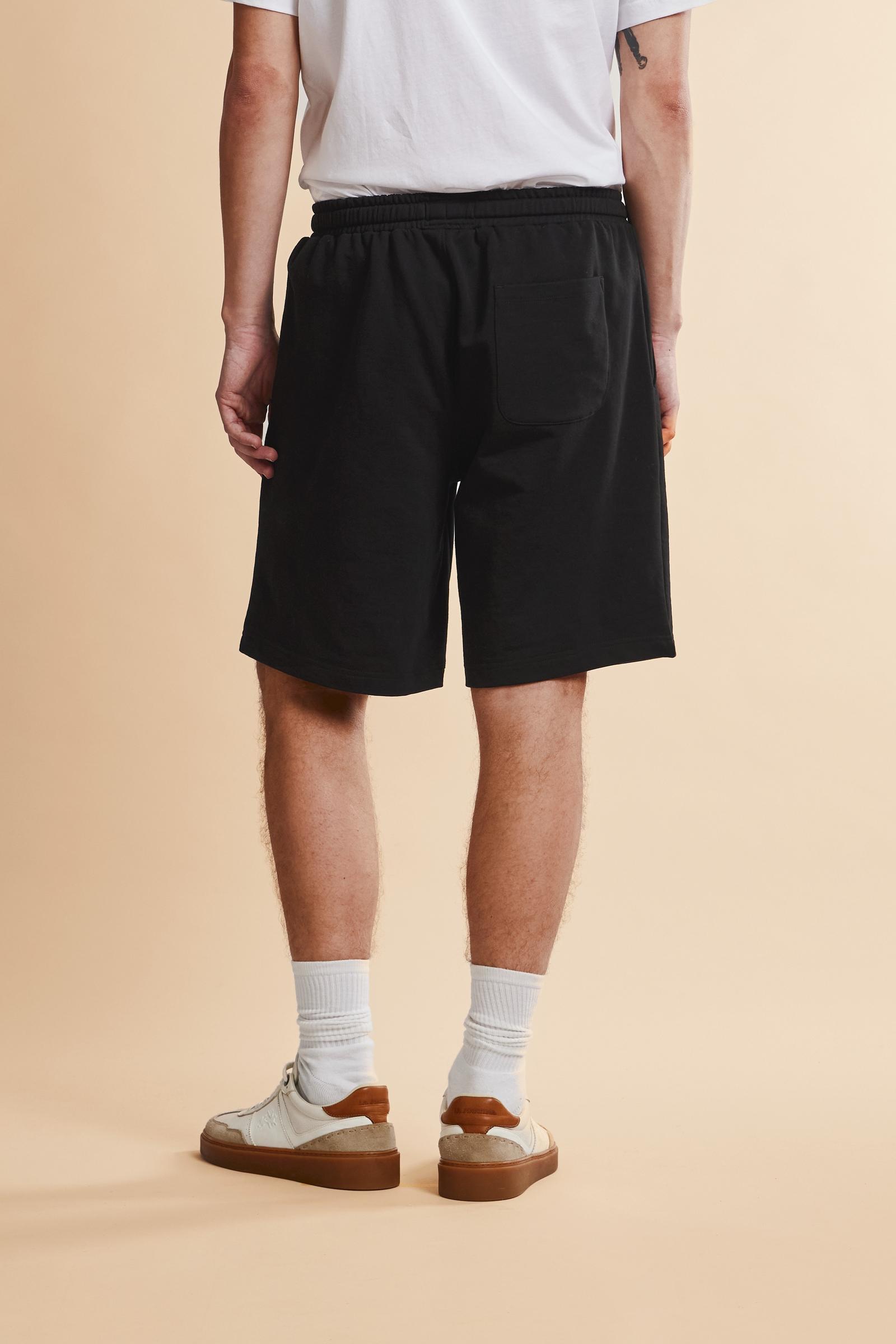Men's bermuda shorts made from soft 100% cotton diagonal fleece. The regular relaxed cut reaches the knee and ensures maximum freedom of movement. The elastic waistband is completed by a flat tone-on-tone drawstring for adjustment. The design is finished with the brand's maxi logo embroidered in contrasting color with a 3D effect on the lower left leg. The model is wearing size L. - Black