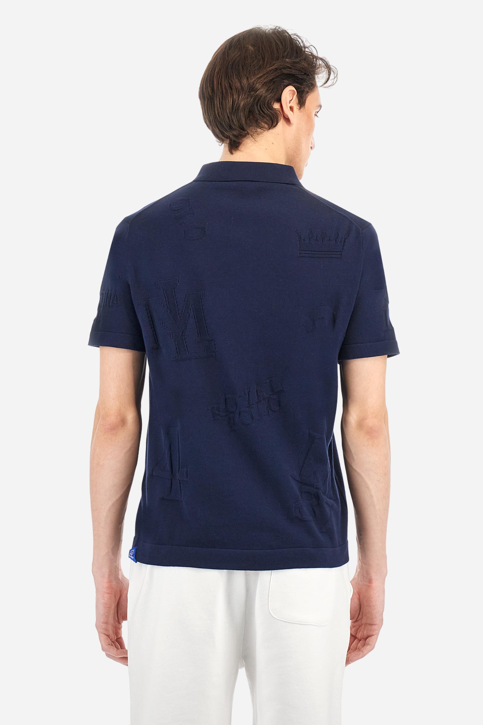 Men's short-sleeved, single-colour knitted polo shirt made of 100% combed cotton yarn. The fastening is with three buttons and the inside of the opening is in vertical rib. Various graphics are present over the garment, made by machine using an inlay technique. The logo on the left side of the chest is embroidered tone on tone. Regular fit. The model is wearing a size L. - Navy