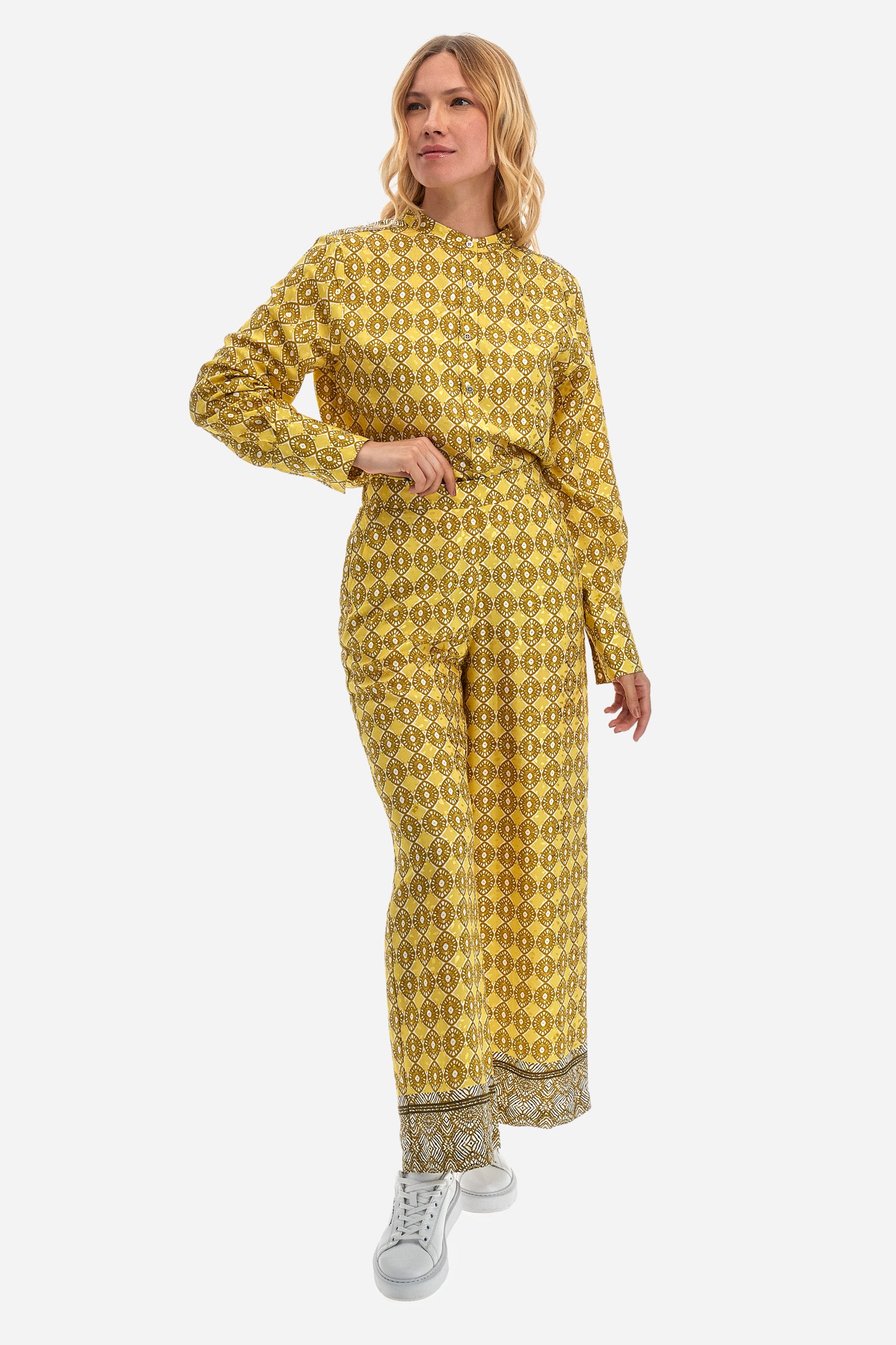 Women's palazzo trousers with geometric prints, made in a synthetic fabric. Elasticated waistband. There are two open front pockets. A metal plate with the logo is sewn on the front. The fit is regular. The model wears a size 2. - Goldfinch/Arrow/Whit