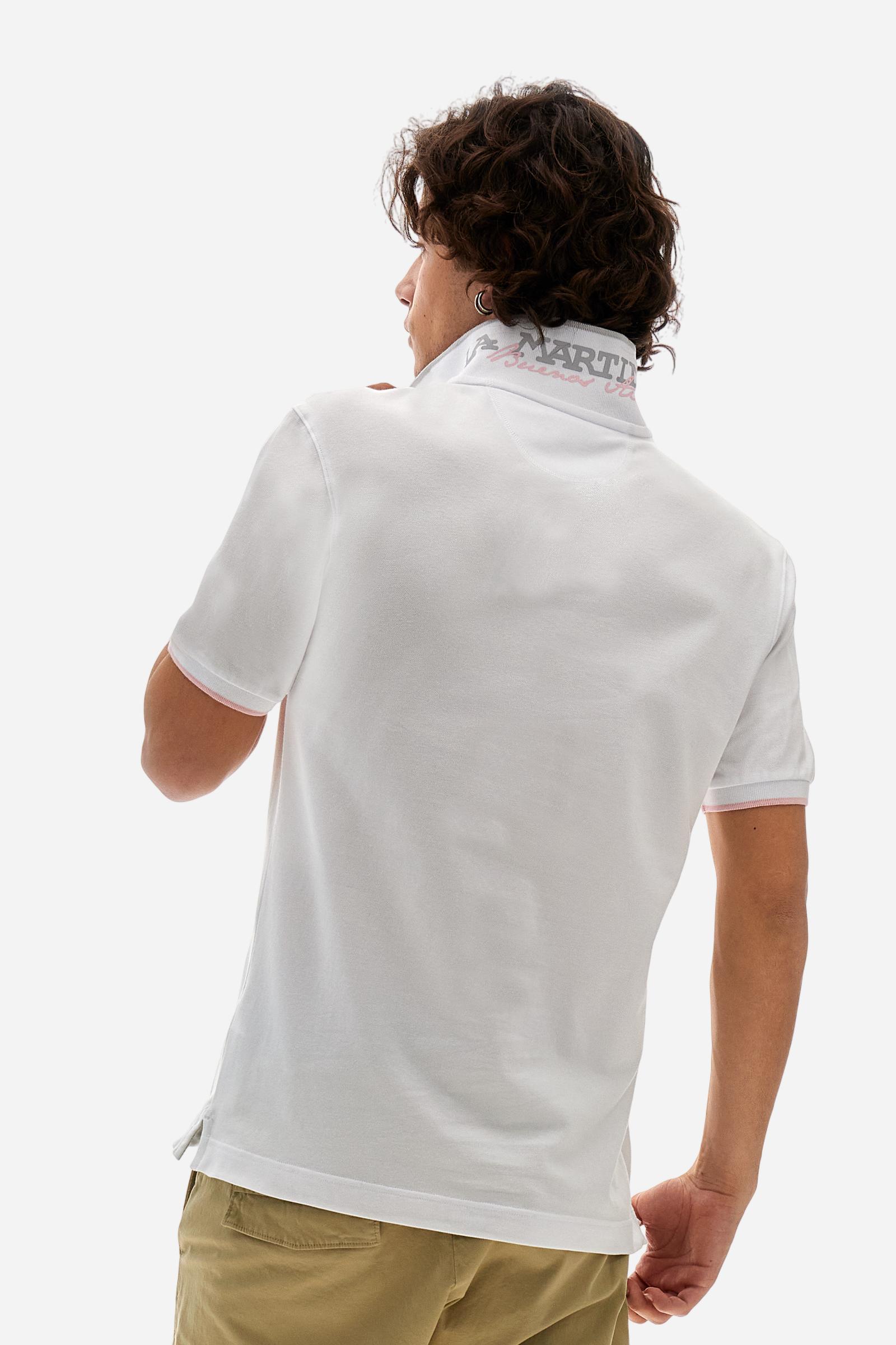 Short-sleeved, single-colour men's polo shirt made of stretch cotton piqué. Fastens with two buttons. The collar and cuffs are ribbed, and there is a colour-contrasting trim at the bottom of the collar. Inside the collar there is a grosgrain ribbon of a different shade. The logo is embroidered on the chest in a contrasting colour. The fit is slim. The model is wearing a size L. - Optic White