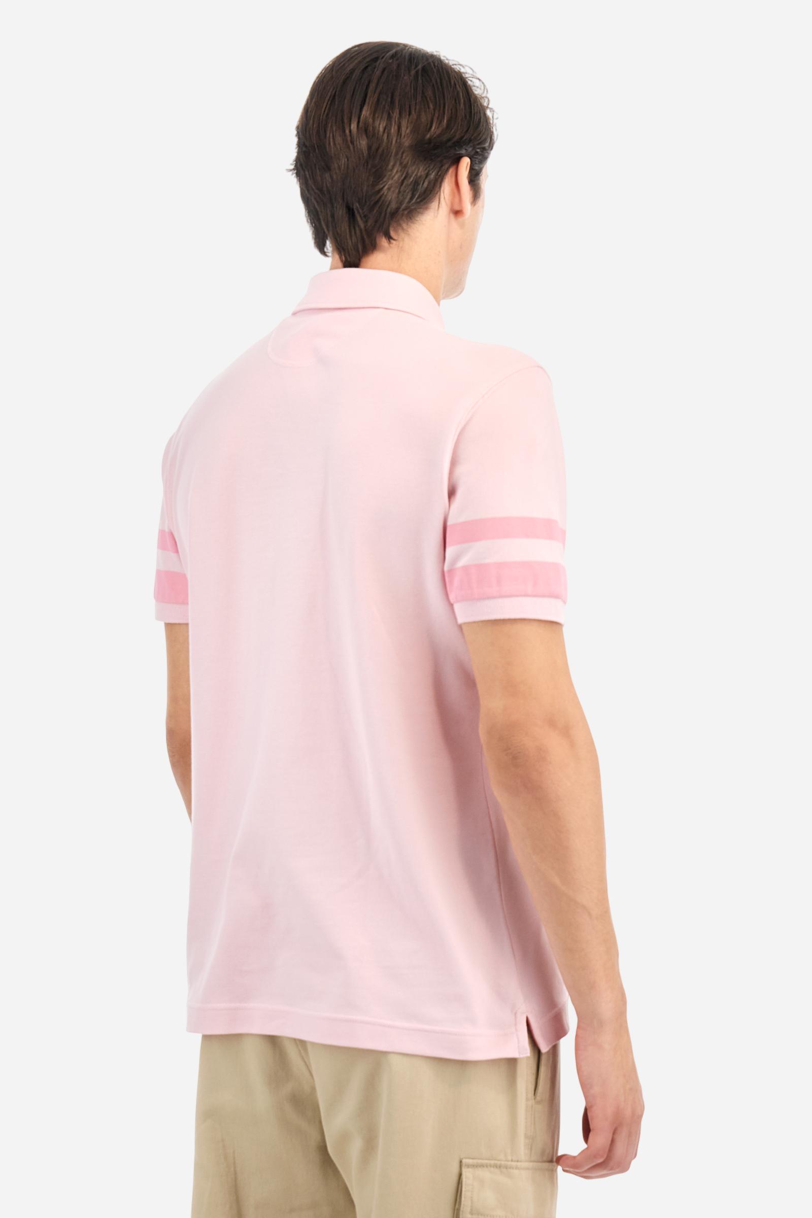 Short-sleeved, single-colour men's polo shirt made of stretch cotton piqué. Fastens with two buttons. Sleeve details in fabric with colour-contrasting irregular band pattern. Ribbed collar with brand name embroidery in contrasting colour. The front graphics are embroidered, the large central lettering is a flocked transfer, while the flag on the sleeve is an applied patch. The logo is embroidered on the chest, left side. The fit is regular. The model is wearing a size L. - Parfait Pink