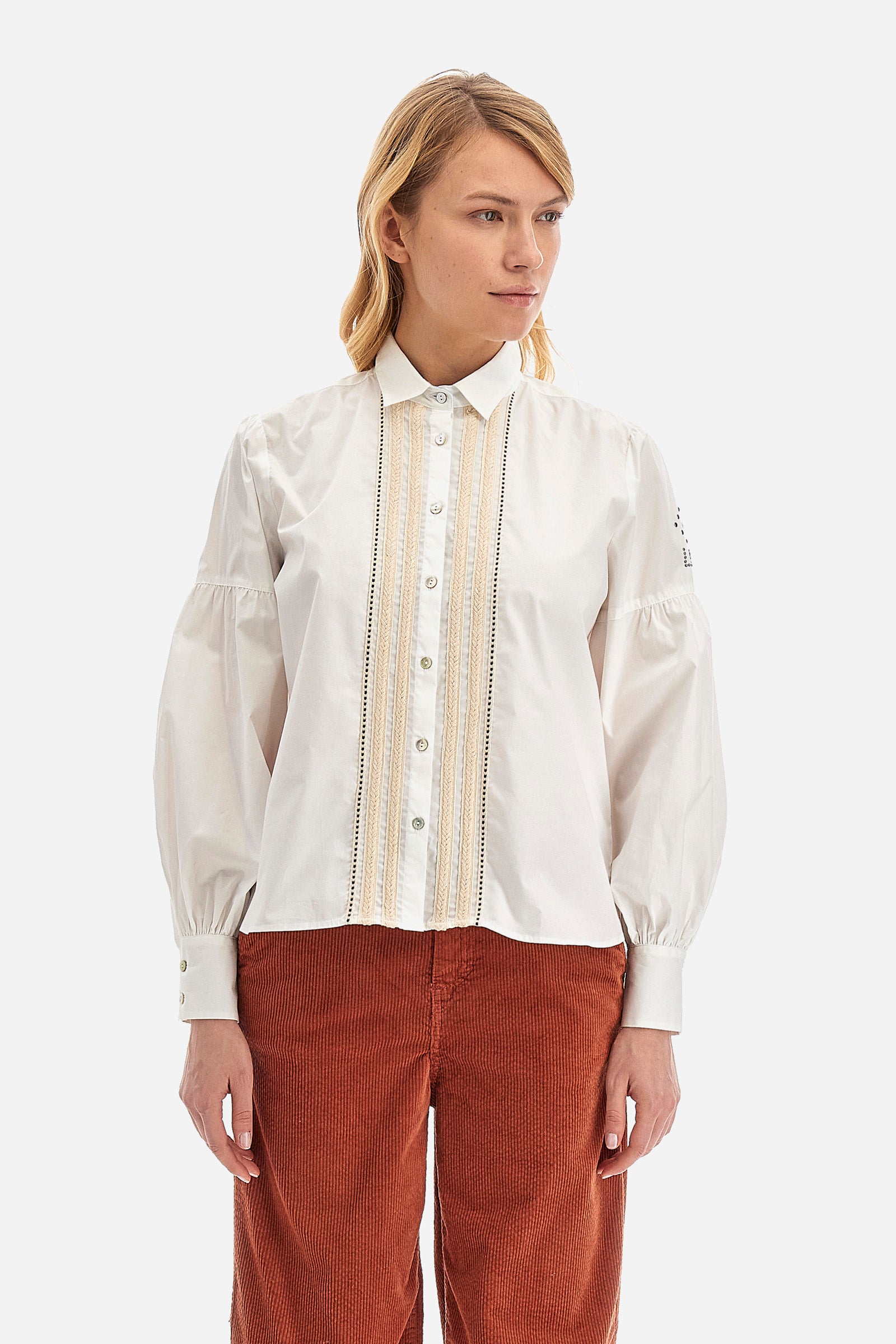 The Argentina women's shirt is made of solid-coloured stretch cotton, with an elegant regular fit. The design features a refined classic collar and button fastening with cable and openwork trims, giving the shirt a distinctive edge. The long sleeves, adorned at the top with a balloon effect, give the shirt a delicate and romantic look. Finally, the LM logo applied the sleeve completes the garment with a sophisticated and contemporary aesthetic. The model is 174 cm tall and wears a size 2. - Optic White