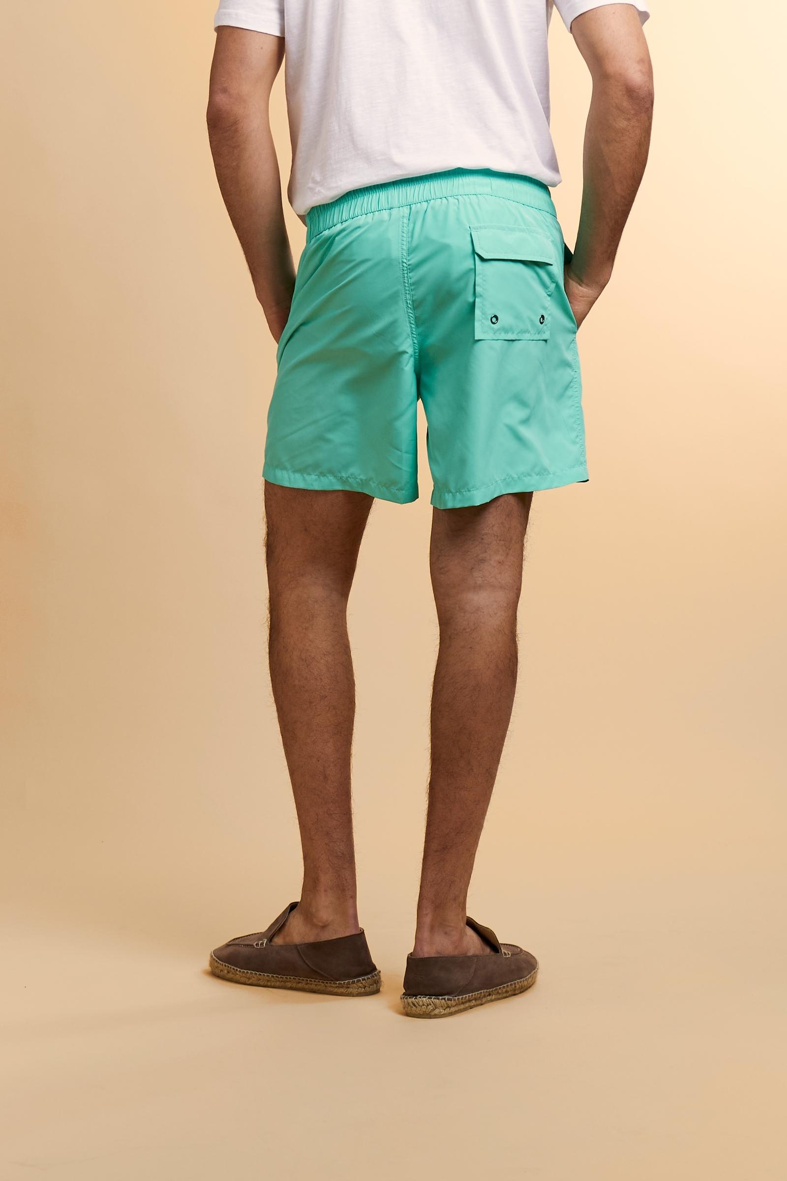 Men’s solid nylon mid-length swim shorts. Regular fit with elasticated waistband, adjustable drawstring, back pocket and embroidered logo. - Opal