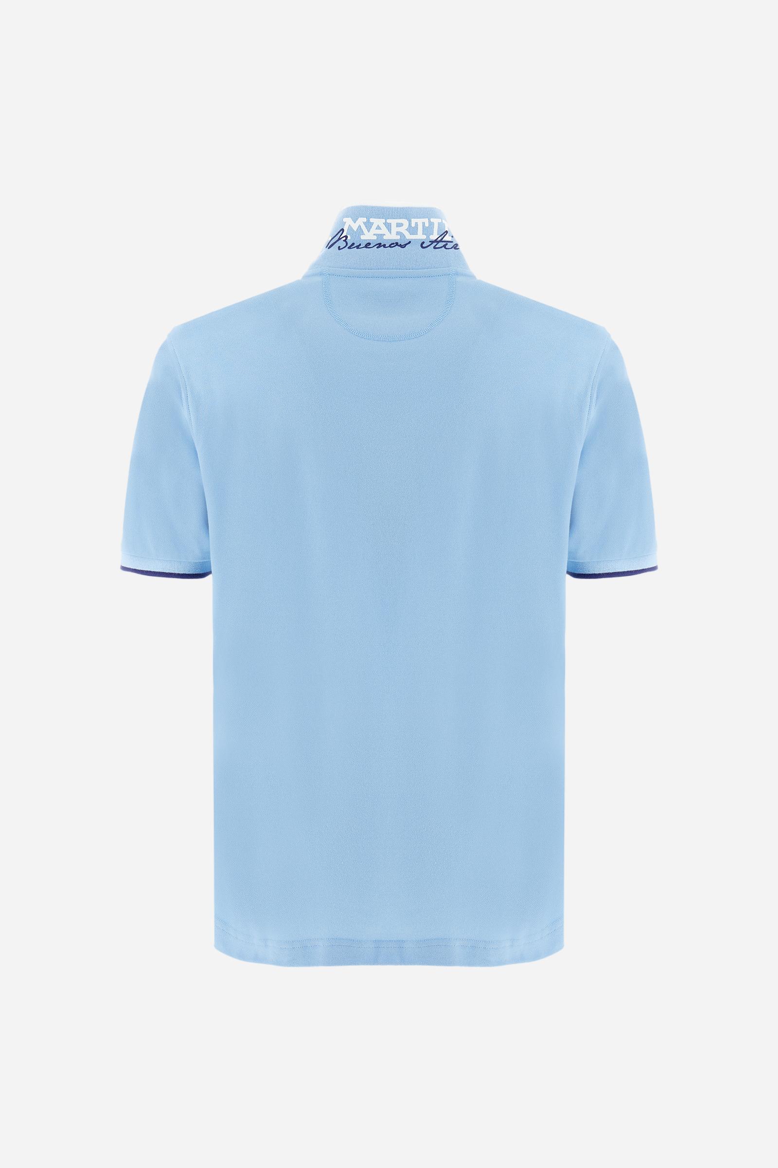 Short-sleeved, single-colour men's polo shirt made of stretch cotton piqué. Fastens with two buttons. The collar and cuffs are ribbed, and there is a colour-contrasting trim at the bottom of the collar. Inside the collar there is a grosgrain ribbon of a different shade. The logo is embroidered on the chest in a contrasting colour. The fit is slim. The model is wearing a size L. - Vista Blue