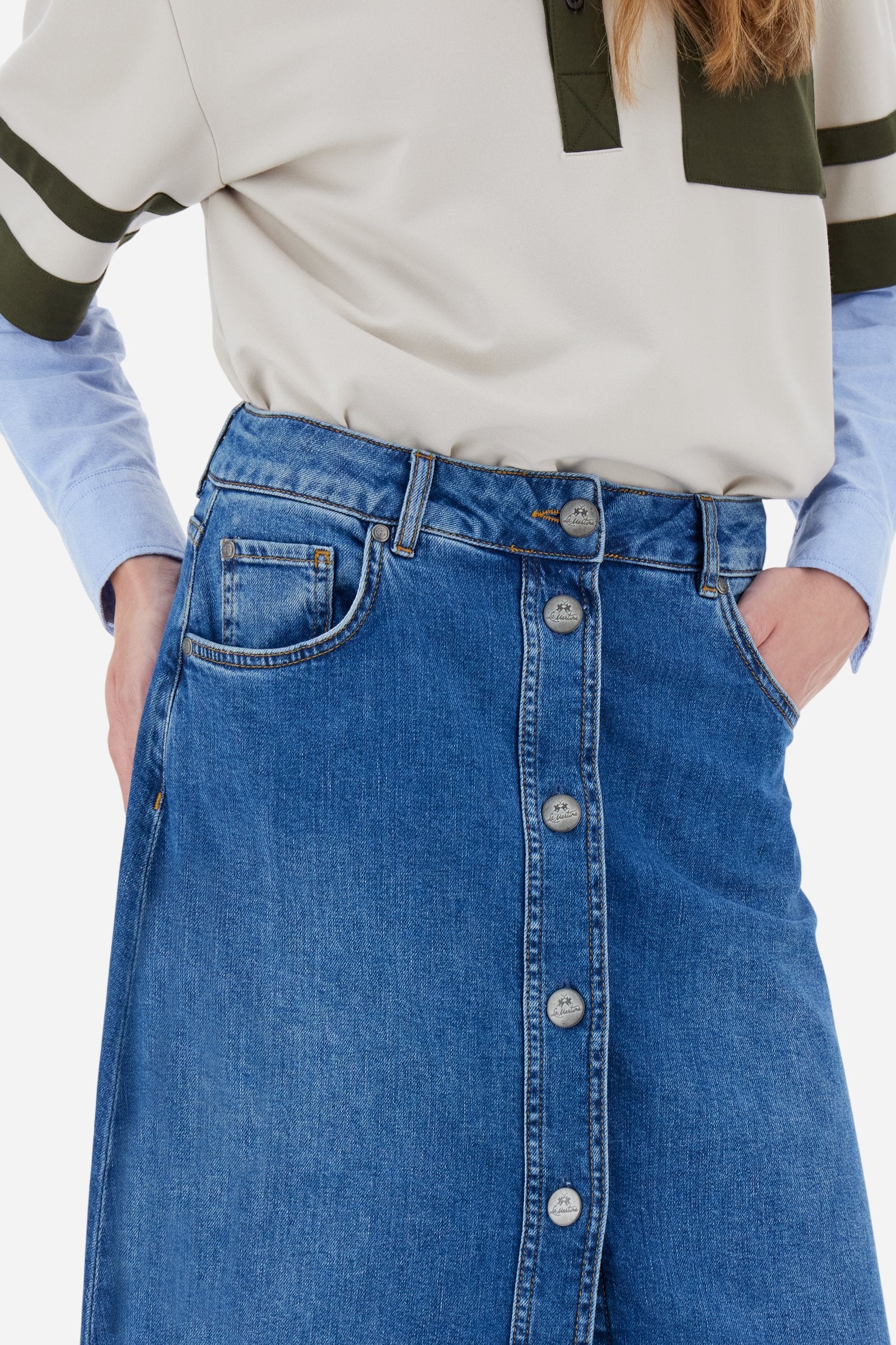 Women's long skirt in stretch cotton denim. 5-pocket model with front opening fastened by custom tack buttons.The logo features on the back of the eco-leather waistband applied to the right of the waist. The flared fit creates a feminine, fluid look. The model is wearing a size 2 - Medium Indigo Denim