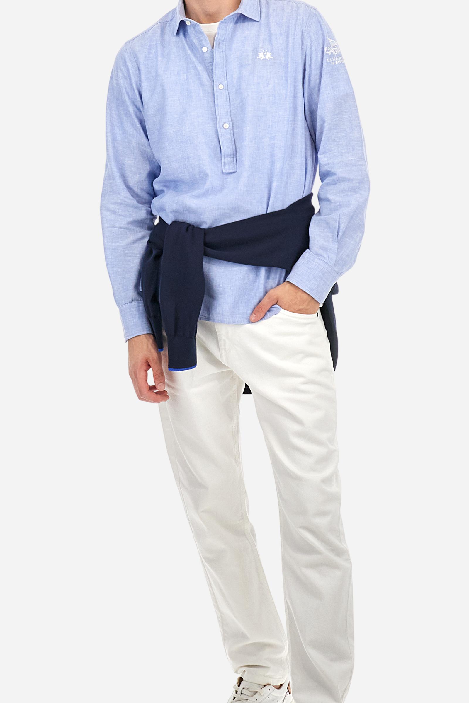 Men's plain long-sleeved shirt, made from luxurious cotton and linen canvas. The spread collar and the opening, which reaches the waist, are closed with 4 buttons. The left bicep is embellished with embroidered graphics depicting lettering, crests and numbers, created using contrasting thread. The logo is embroidered in contrasting thread on the left side of the chest. The regular fit offers a refined and comfortable look. The model is wearing a size L. - Cornflower blue