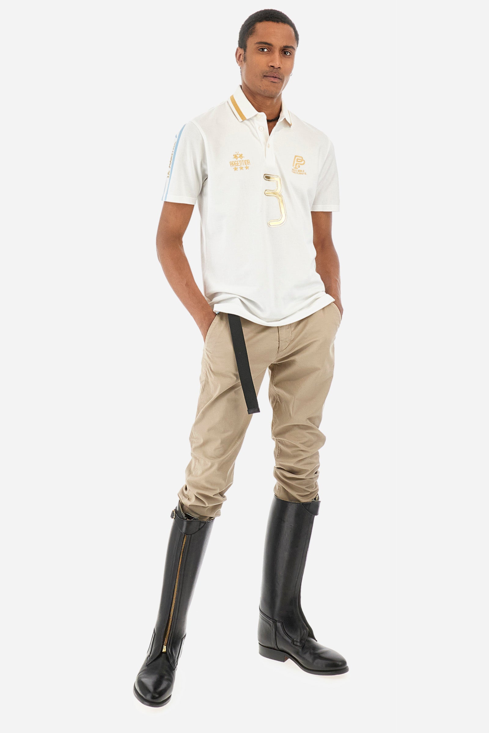 Men's single-colour short-sleeved polo in elasticated cotton. Three-button fastening. Collar with contrasting colour stripe. The front features embroidered lettering, the number 3, the word "Argentina", and a small logo. On one sleeve we find the "La Martina" lettering with two stripes in the colours of the Argentinian flag. The back features additional "Argentina" lettering, a print of the number 3, and symbols representing the nation. The fit is regular. The model wears a size L. - Optic White