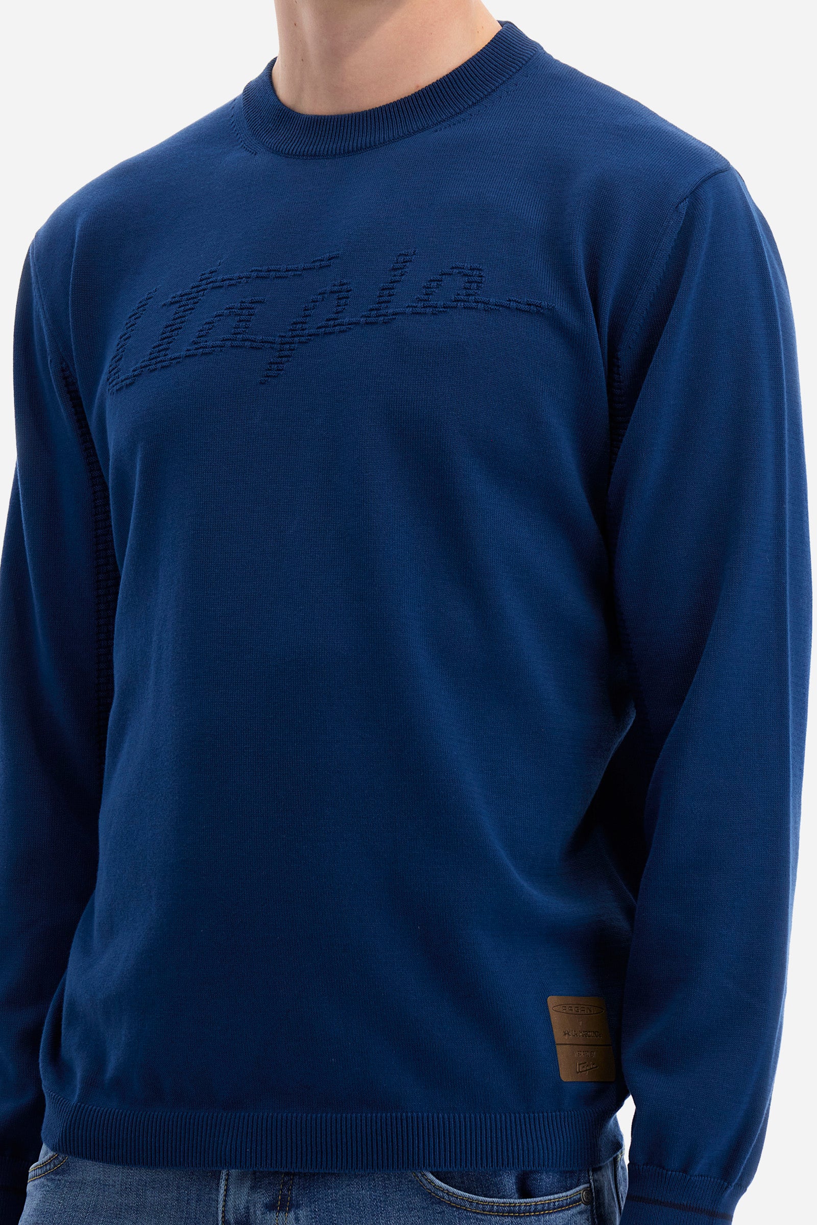 Men's long-sleeved crew-neck jumper in a single colour in collaboration with Pagani. Made from 100% cotton. Some parts of the garment have a woven basket stitch texture. Ribbed cuffs, neck and waist. The front features the line's characteristic lettering. The logo and "La Martina" and "Pagani" lettering are present on the patch representing the collaboration applied on both the front and back. The fit is regular. The model wears a size L. - Ensign Blue