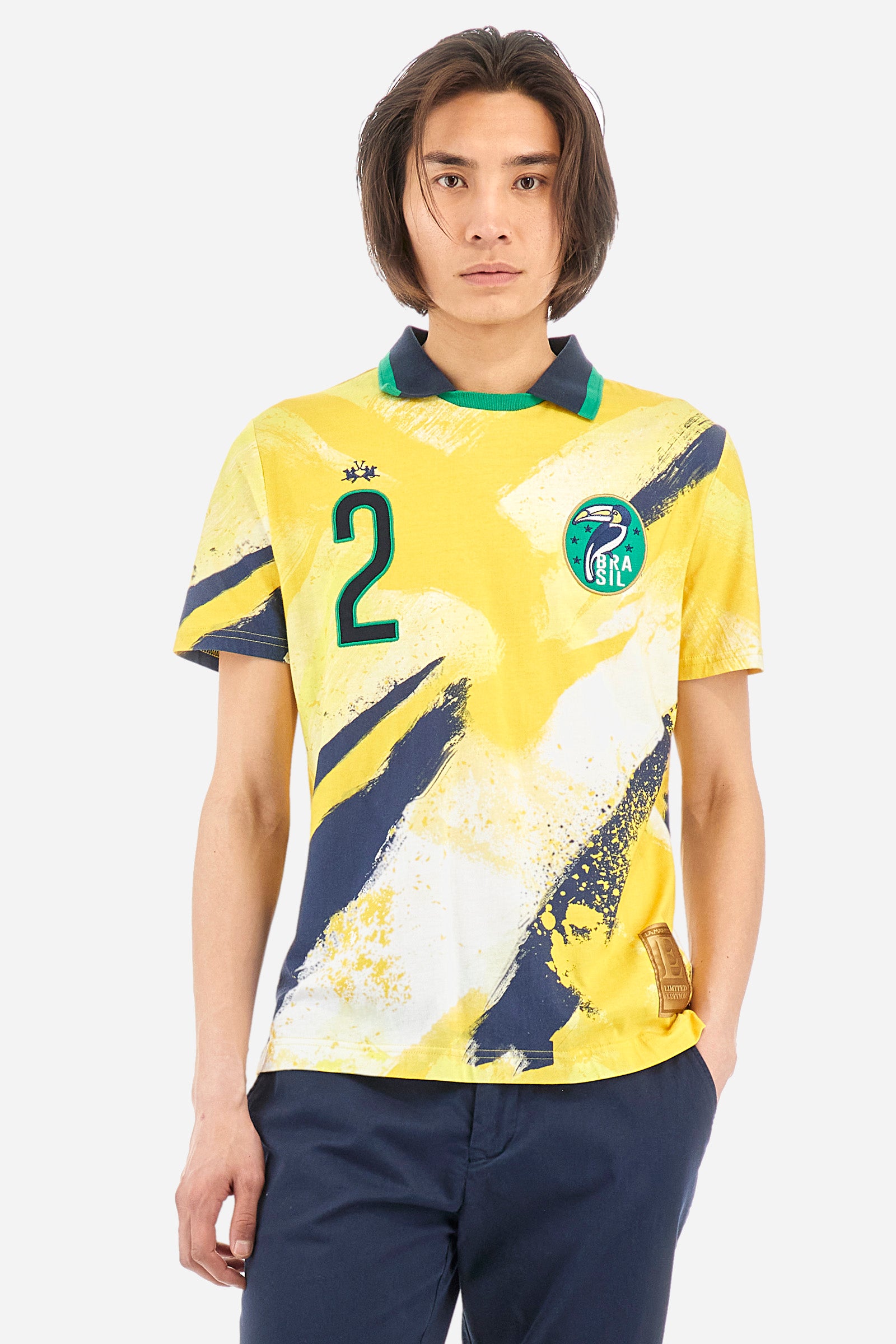 Men's multi-coloured short-sleeved polo shirt in 100% cotton. Crew-neck polo shirt with pointed collar featuring the representative colours of Brazil. On the chest there is a patch with the number 2 and a patch with a characteristic symbol of the nation. On the back we find the word "Brazil", the number two and other symbols. The logo is embroidered on both the front and back. The fit is regular. The model wears a size L. - SulphurSpring/OptWhi