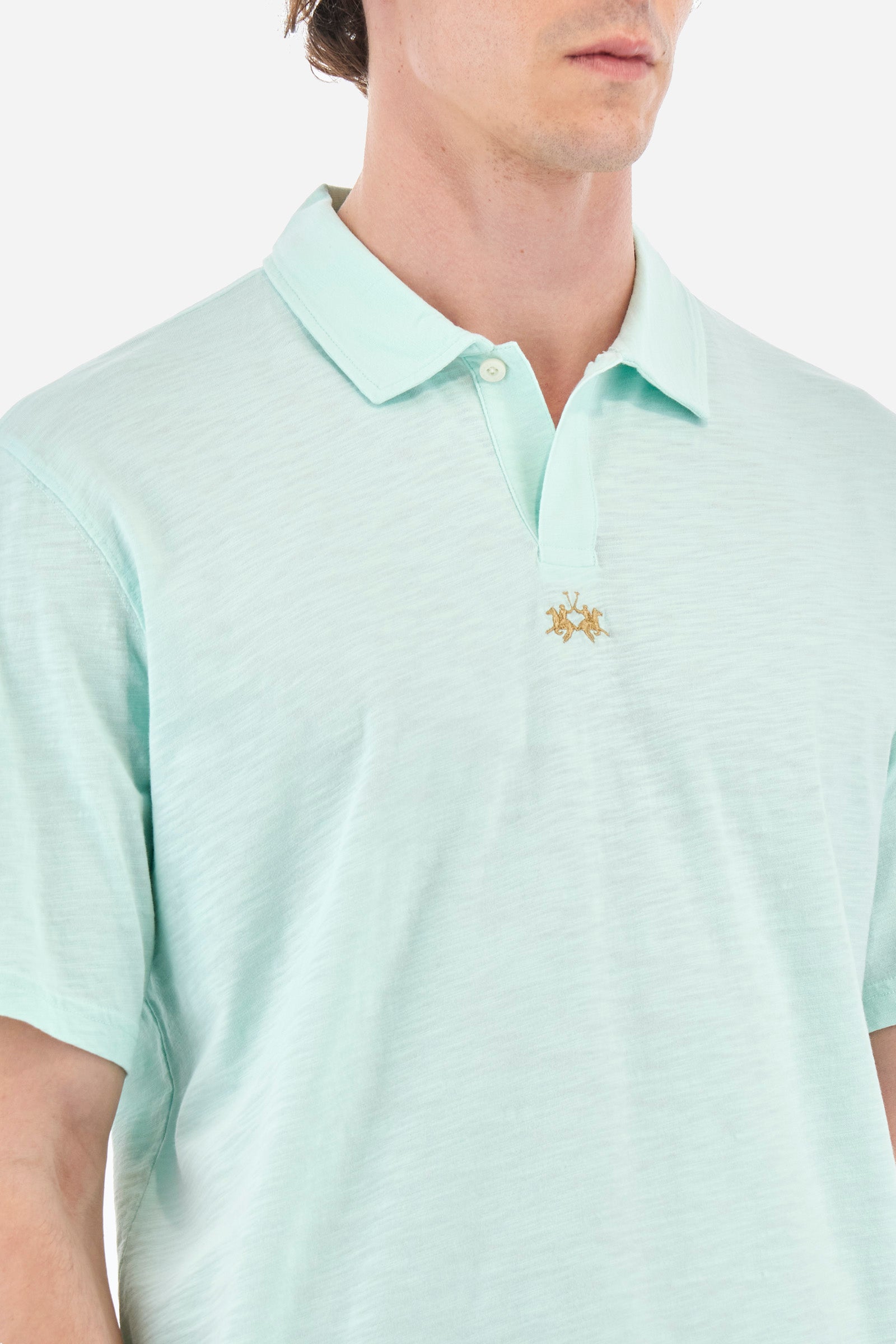 Men's single-colour short-sleeved polo shirt in 100% cotton. Fastens with a button. Tone-on-tone stitching. Pointed collar. Featuring a small embroidered logo on the front. The fit is regular. The model wears a size L. - Honeydew