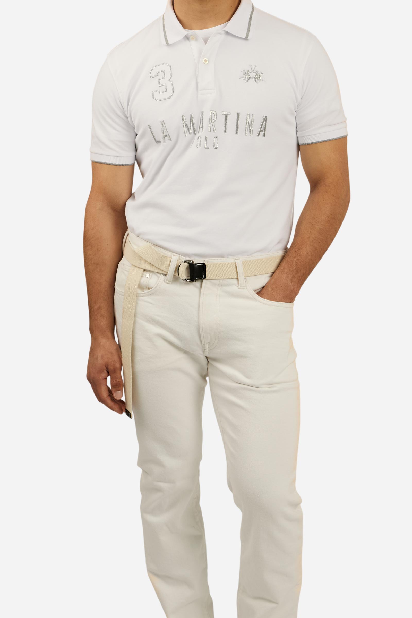 Men's plain short-sleeved polo shirt made from stretch piqué. Two-button fastening. The collar and cuffs are made from ribbed fabric with narrow contrasting trim at the bottom. The large La Martina Polo lettering on the chest is embroidered in contrasting thread. The number 3 patch appliquéd on the right side of the chest and the logo on the left side are also embroidered using contrasting thread. Regular fit. The model is wearing a size L. - Optic White