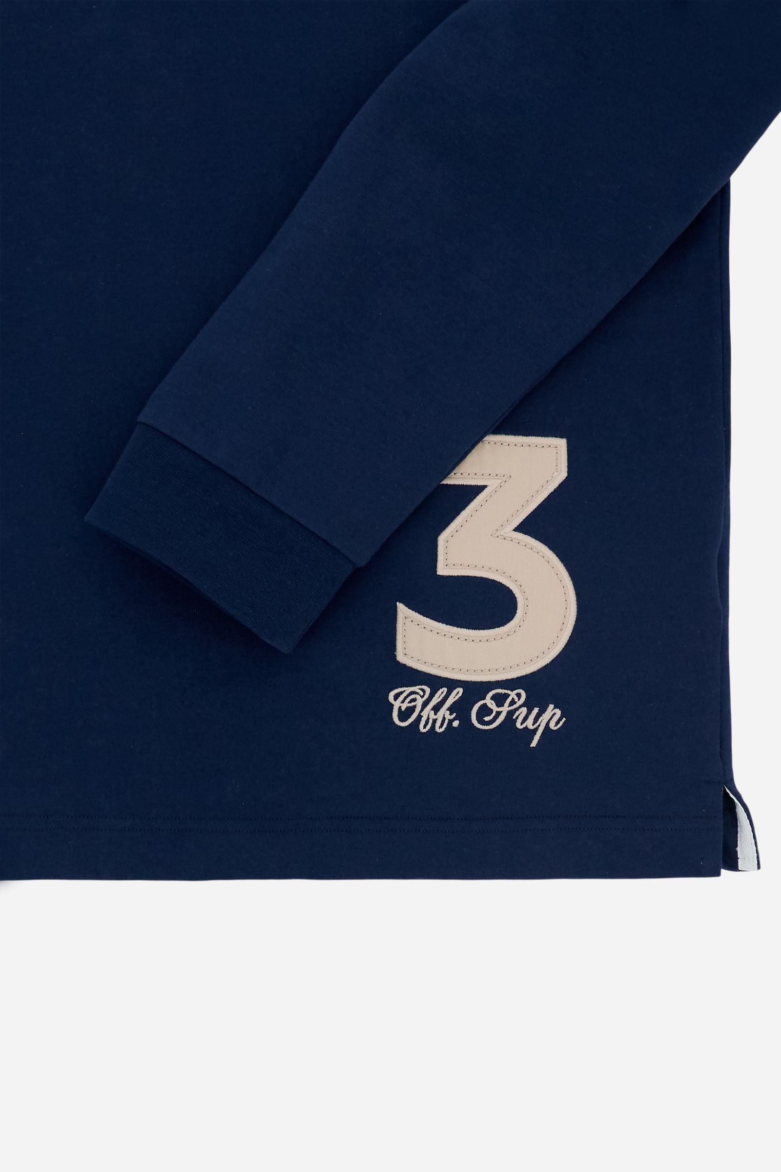 Men’s long-sleeve polo in heavy cotton jersey. Rugby construction with contrast gabardine collar and three-button placket. Ribbed cuffs and compact structure enhance the silhouette. A refined mix of raised embroidery and applied patches decorates chest, back and sleeves. Iconic logo embroidered beneath the placket. The model wears size L. - Navy