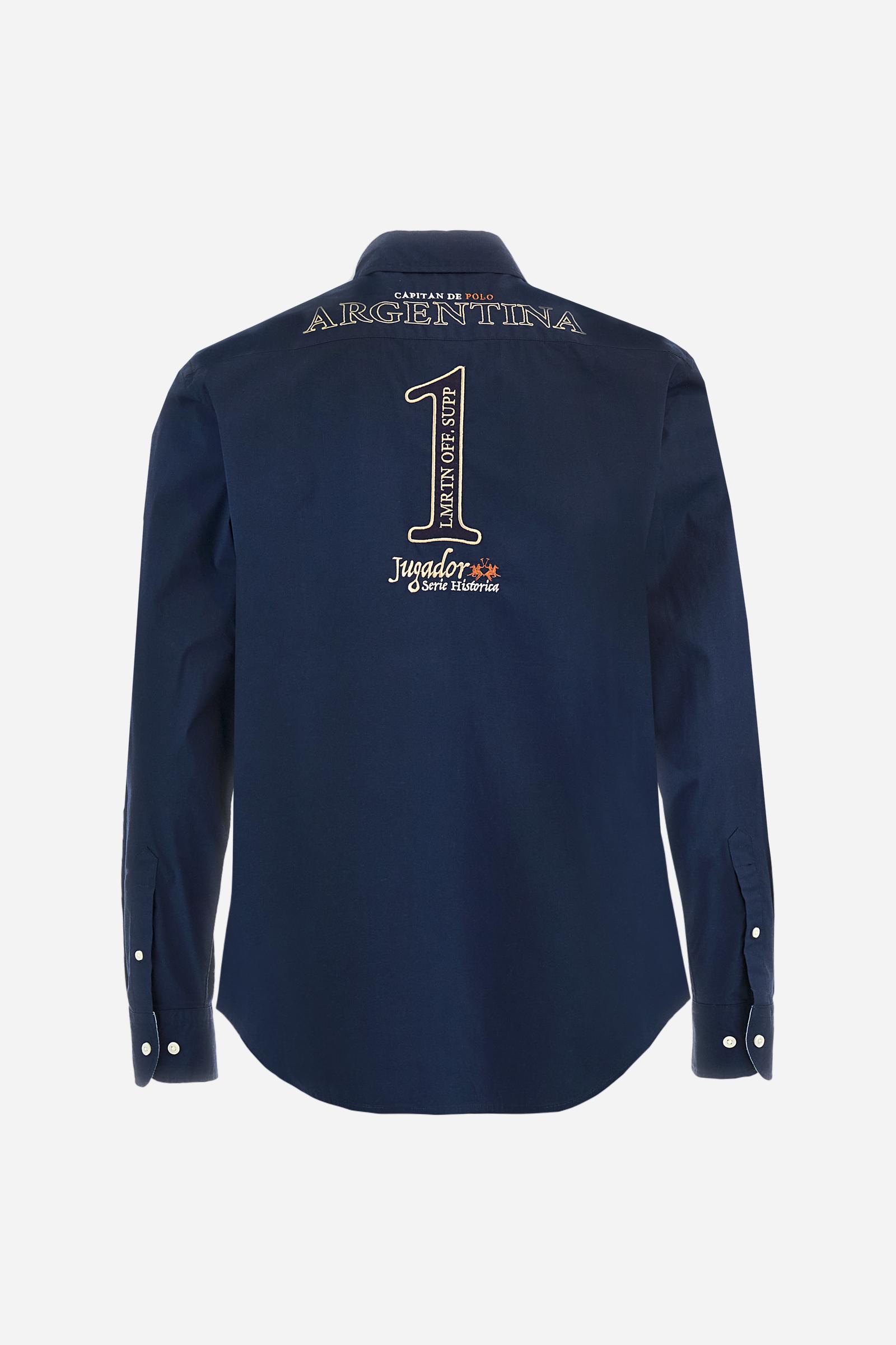 Men’s long-sleeved shirt made from stretch cotton poplin in solid color. Classic button placket with visible personalized buttons and button-down collar with contrasting inner details. Adorned with multiple embroidered graphics on the chest, sleeves, and back celebrating La Martina as the Official Supplier of Argentina. Regular, classic fit. The model wears size L. - Navy