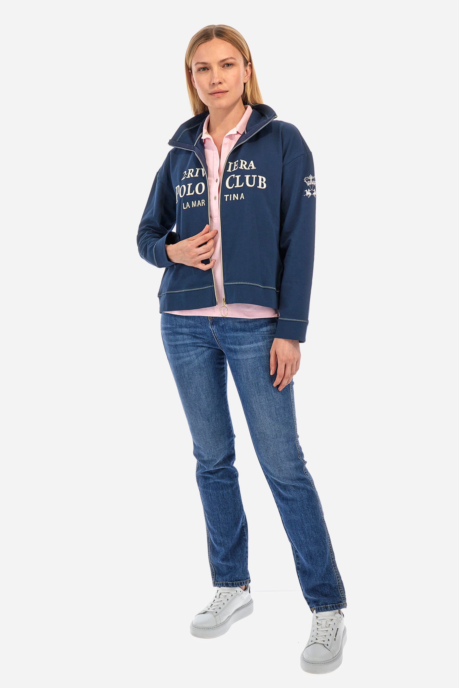 Women’s sleeveless polo shirt in solid color, made of stretch cotton. V-neck and 2 button closure. Collar and crew sleeves profiled and ribbed. Side slits. On the back there is the inscription "La Martina" composed of small rhinestones. The logo is present on the front. The fit is regular. The model wears a size 2 . - Almond Blossom