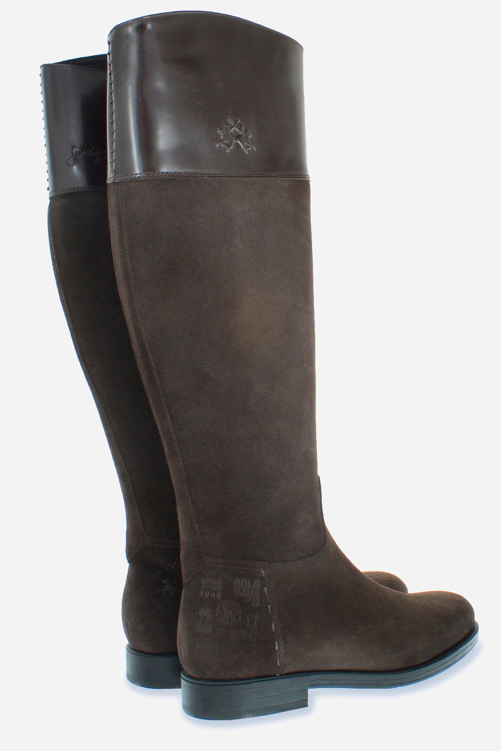 A clean-cut, equestrian-inspired women's boot in suede with soft cowhide at the top of the boot leg.An emblematic model with the unique savoir-faire of La Martina. The horse logo is embossed on the side upper leg. Customised metal rivet detailing on the lower side. This is complemented by the craftsmanship of the hand-stitching. With an extremely versatile and current country chic style. - DARK BROWN