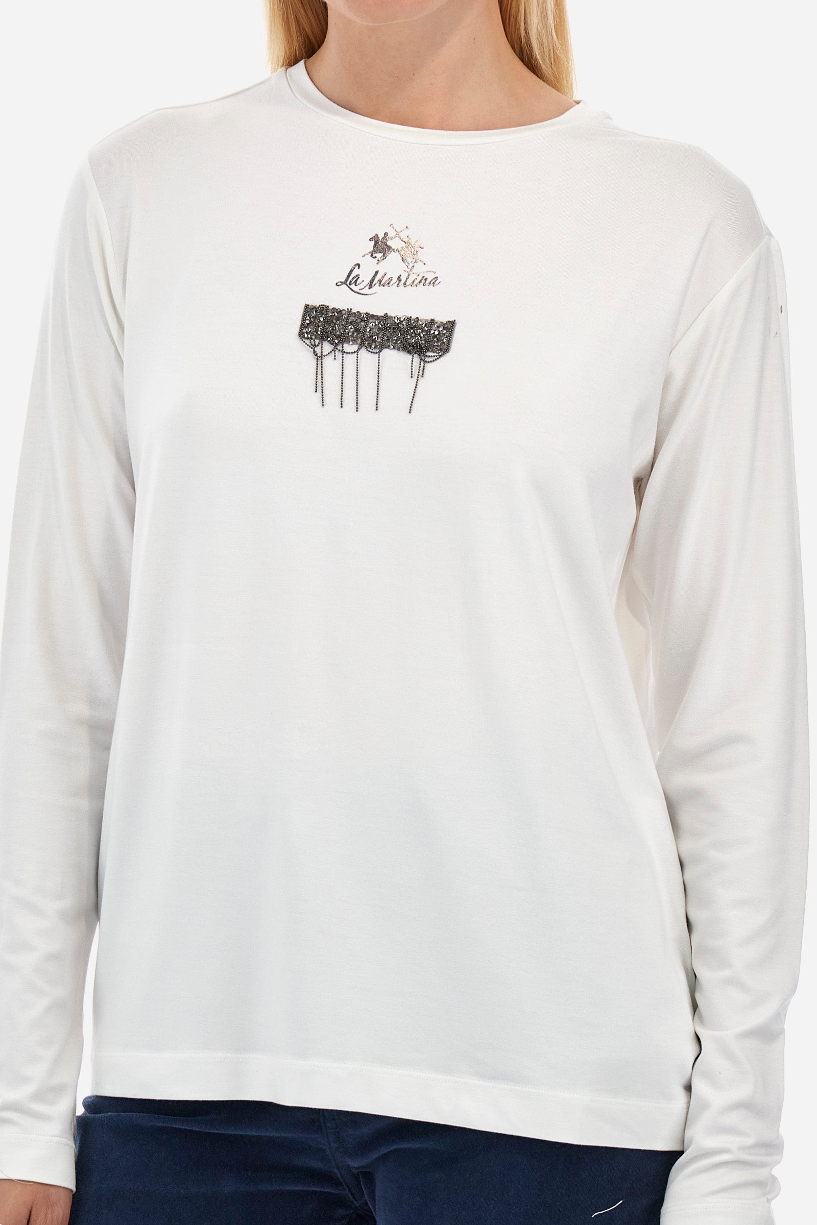 This long-sleeved women's T-shirt is made of stretch viscose for optimal comfort. The regular fit is perfect for any occasion. It features a basic solid colour suitable for any outfit. The crew-neck is enriched with a logo and a jewel detail for a touch of elegance. A versatile and quality garment for every woman's wardrobe. The model is 174 cm tall and wears a size 2. - Off White