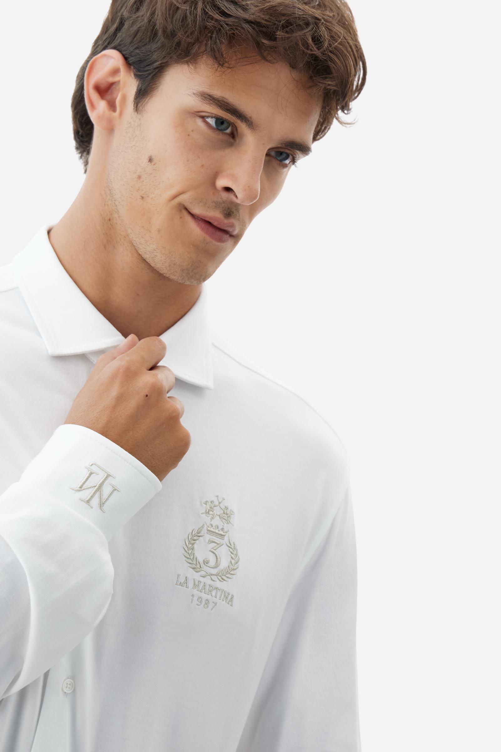 Men's long-sleeved shirt with semi-cutaway collar. It is made of 100% cotton piqué with contrasting details on the inside of the collar. The logo is embroidered on the chest with subtle Polo Club-inspired customisation. The fit is regular and offers a classic, relaxed silhouette. The model is wearing a size L. - Optic White