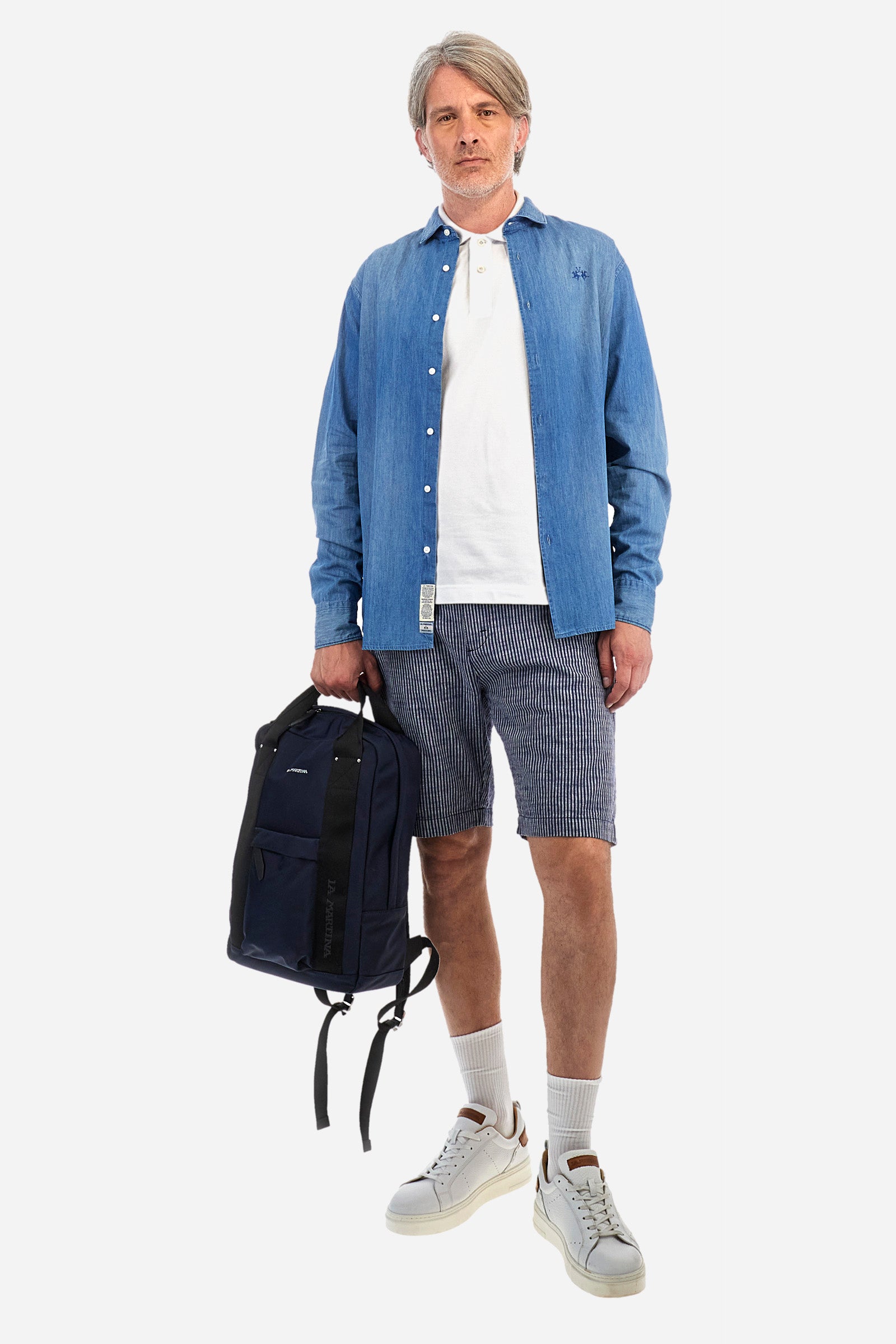 Striped men's Bermuda shorts made from luxurious cotton and linen canvas. Fastened with a zip and faux horn button. The side pockets are slanted, while the double welt back pockets are feature visible faux horn buttons and double-needle stitching around the edges. Above the right back pocket, a woven label explains the brand's quality certification. On the right hem, a graphic reading La Martina is embroidered in colourful thread. Regular fit. The model is wearing a size L. - EnsignBlue/Opt.White