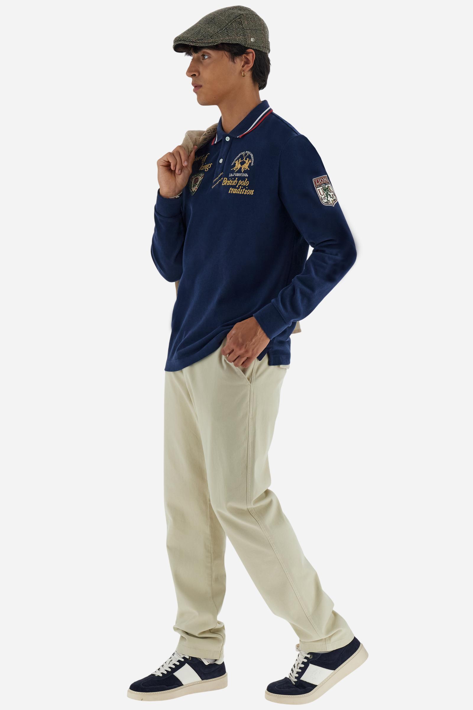 Men’s long‑sleeve polo in soft‑touch cotton jersey with warm, cosy handfeel. Two personalised buttons and contrast zigzag stitch at placket edge; contrast rib collar with multicolour striping and regimental neck tape. Multicolour chest and sleeve graphics inspired by the Sport of Kings and British polo; large contrast Team logo at chest. Regular fit. Model wears size L. - Navy