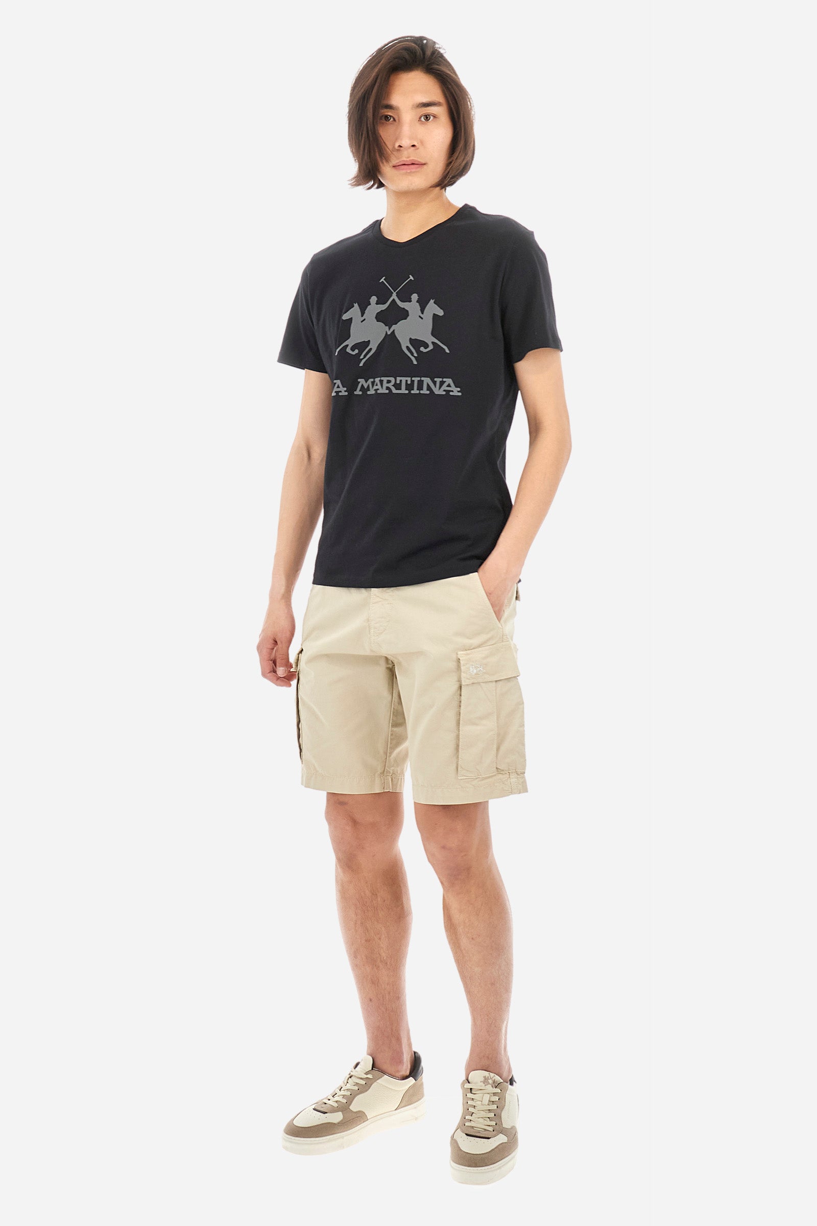 Men's short-sleeved T-shirt with crew neck and solid colour. It features a large printed logo on the front and is made of 100% cotton with a regular fit. It can be combined with trousers for a casual and modern look. The model is 187 cm tall and wears a size L. - Black