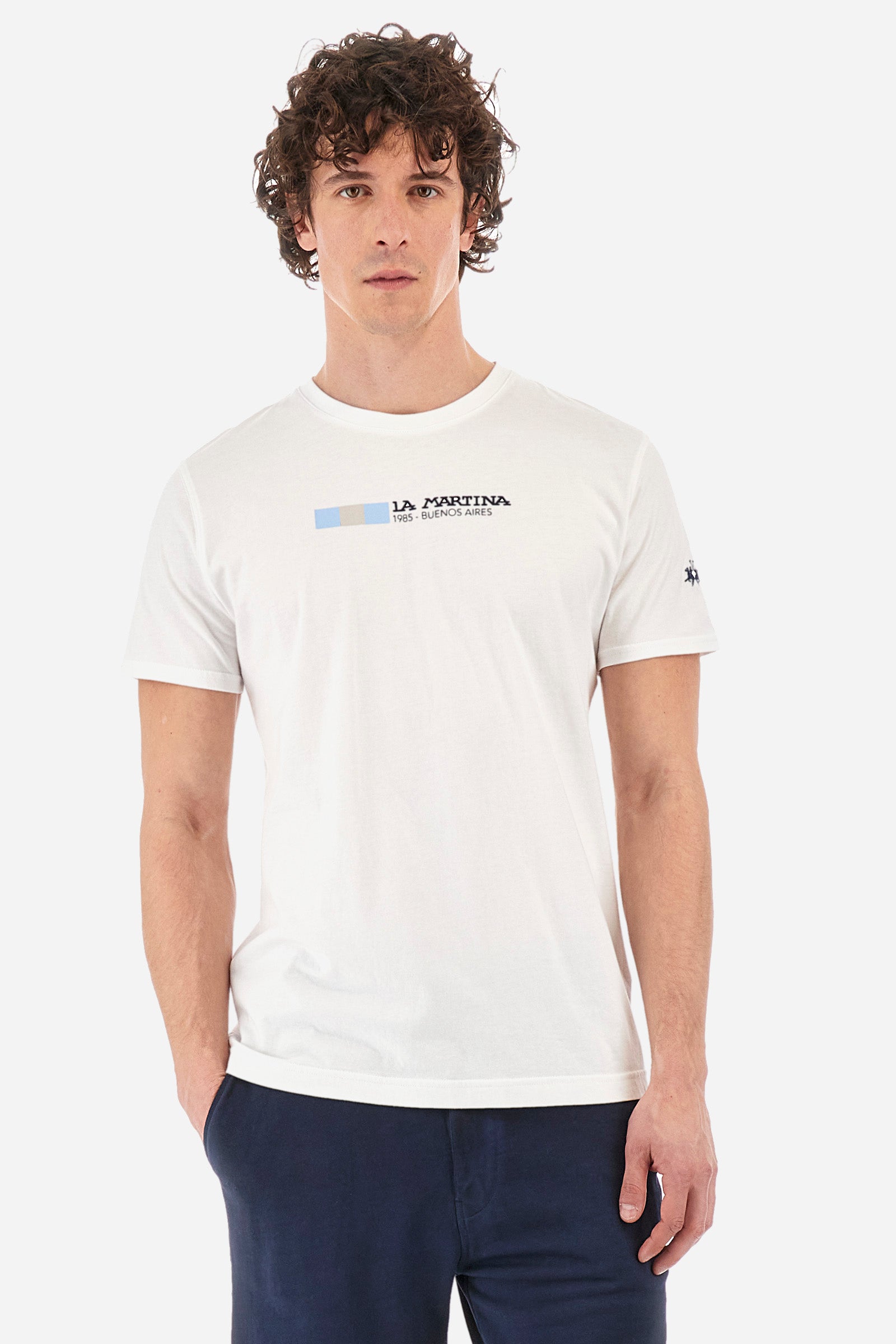Men's short-sleeved T-shirt with a crew neck in a single colour. Made of 100% cotton. On the front we find the lettering "La Martina 1985- Buenos Aires" with the Argentinian flag. A small logo is embroidered on one of the sleeves. Regular fit. The model wears a size L. - Optic White