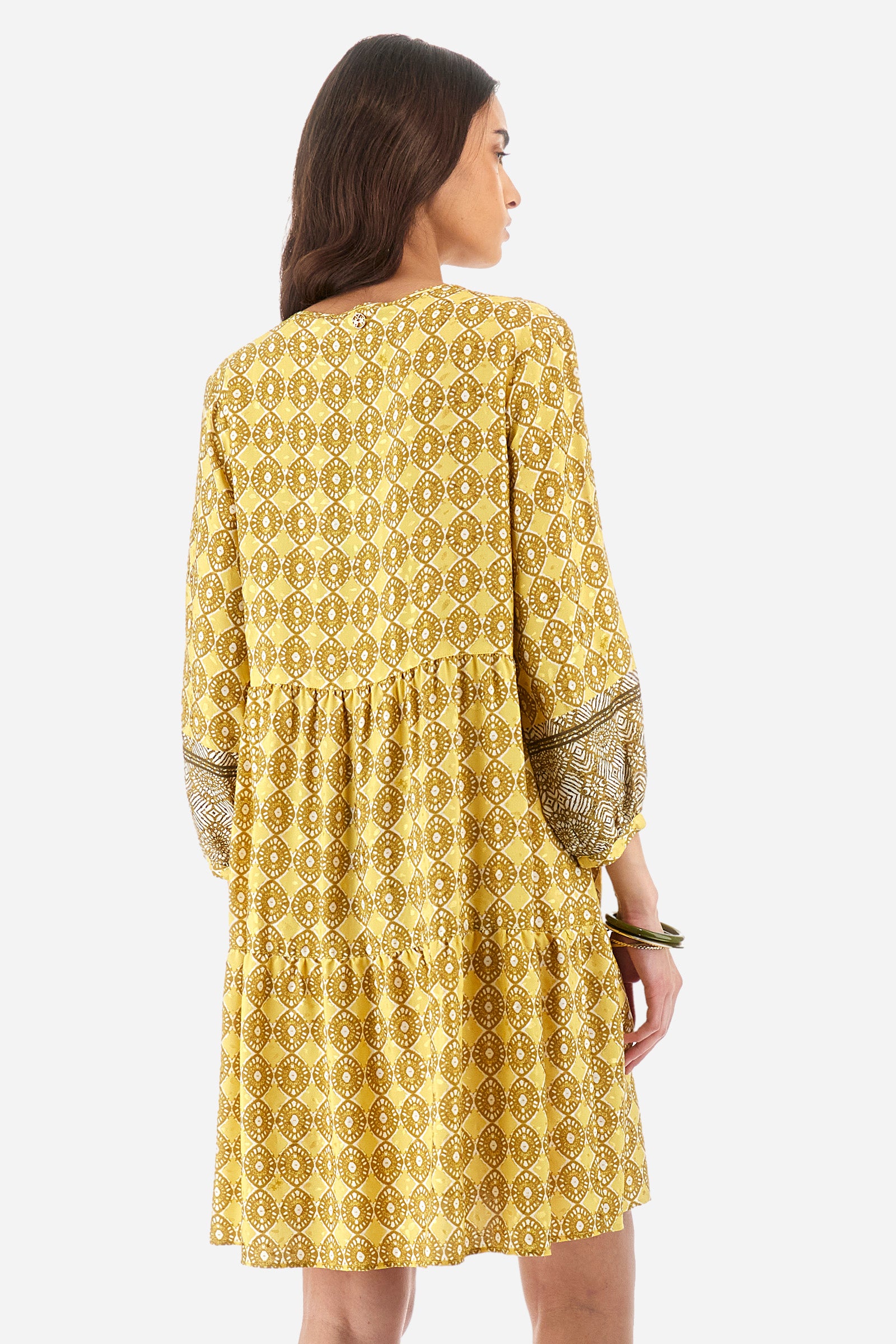 Women's geometric print dress with 3/4 sleeves. In a synthetic fabric. V-neck, tie at the neck and pleats on the chest. Soft, bell-shaped silhouette, knee-length. The fit is regular. The model wears a size 2. - Goldfinch/Arrow/Whit