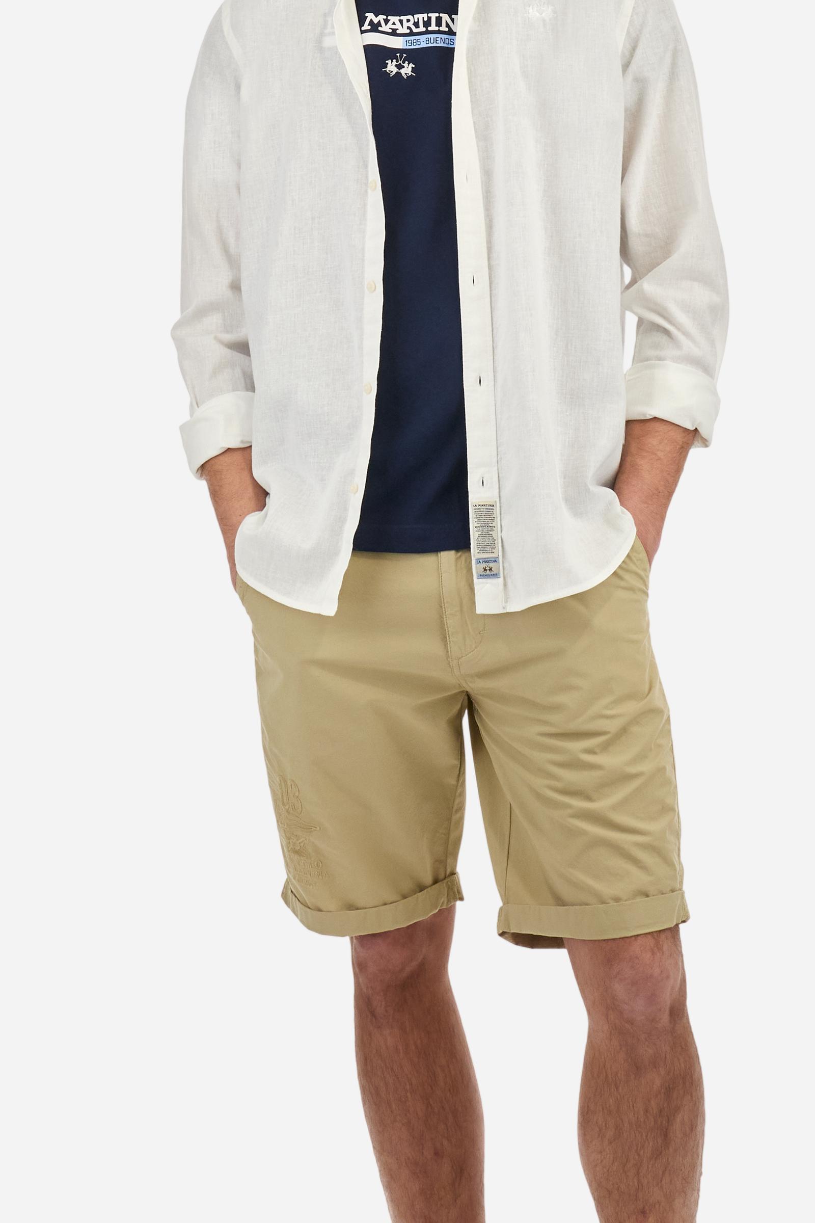 Men's plain long-sleeved shirt made from linen canvas. It features a button-down collar and a basic, traditional design, with woven labels at the bottom of the opening. The logo is embroidered on the chest, over the heart, in tone-on-tone thread. Regular fit. The model is wearing a size L. - Optic White