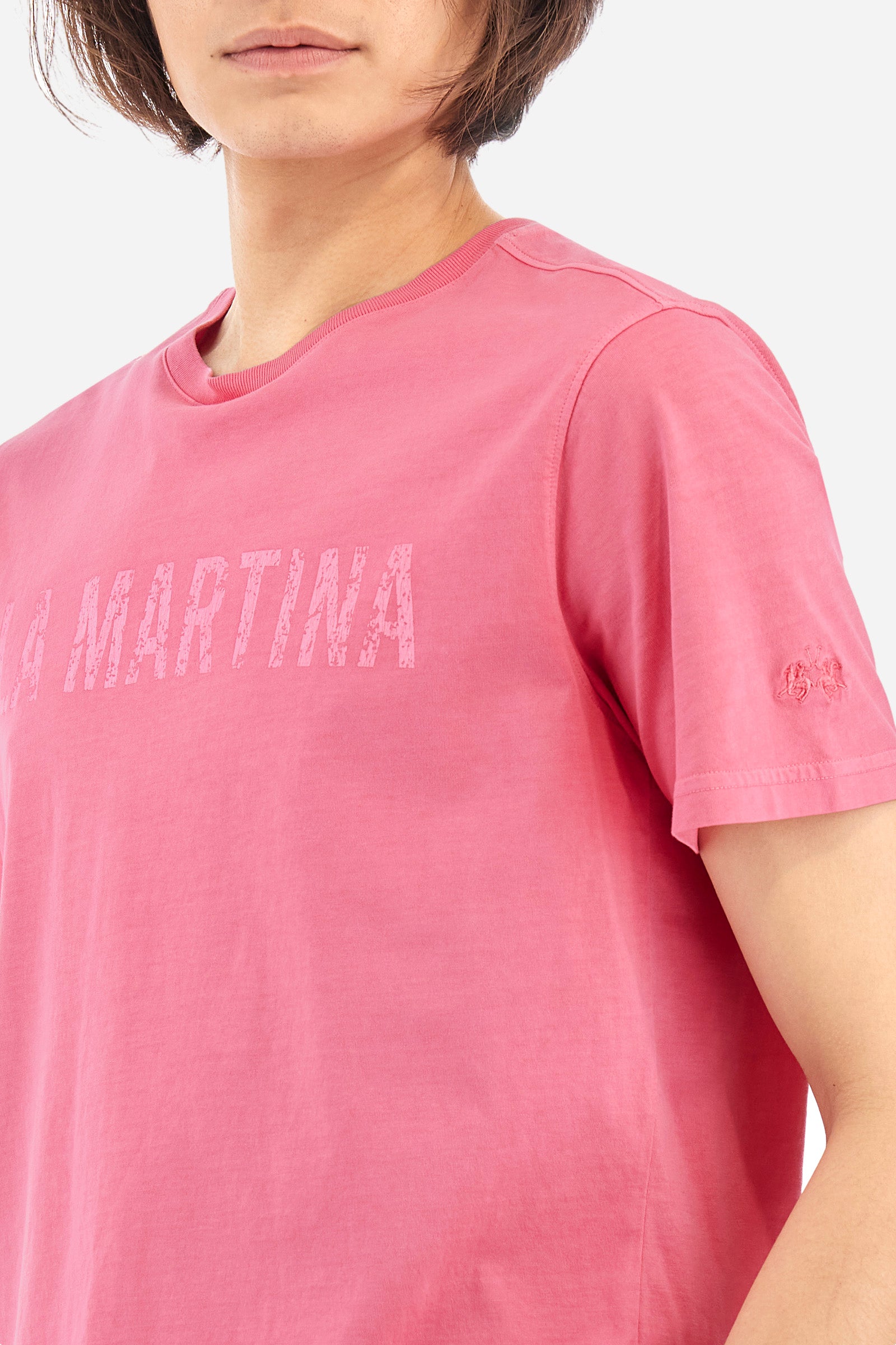Men's short-sleeved T-shirt with a crew neck in a single colour. Made of 100% cotton. On the front we find the writing "La Martina". A small logo is embroidered tone-on-tone on one of the sleeves. Regular fit. The model wears a size L. - Hot Pink