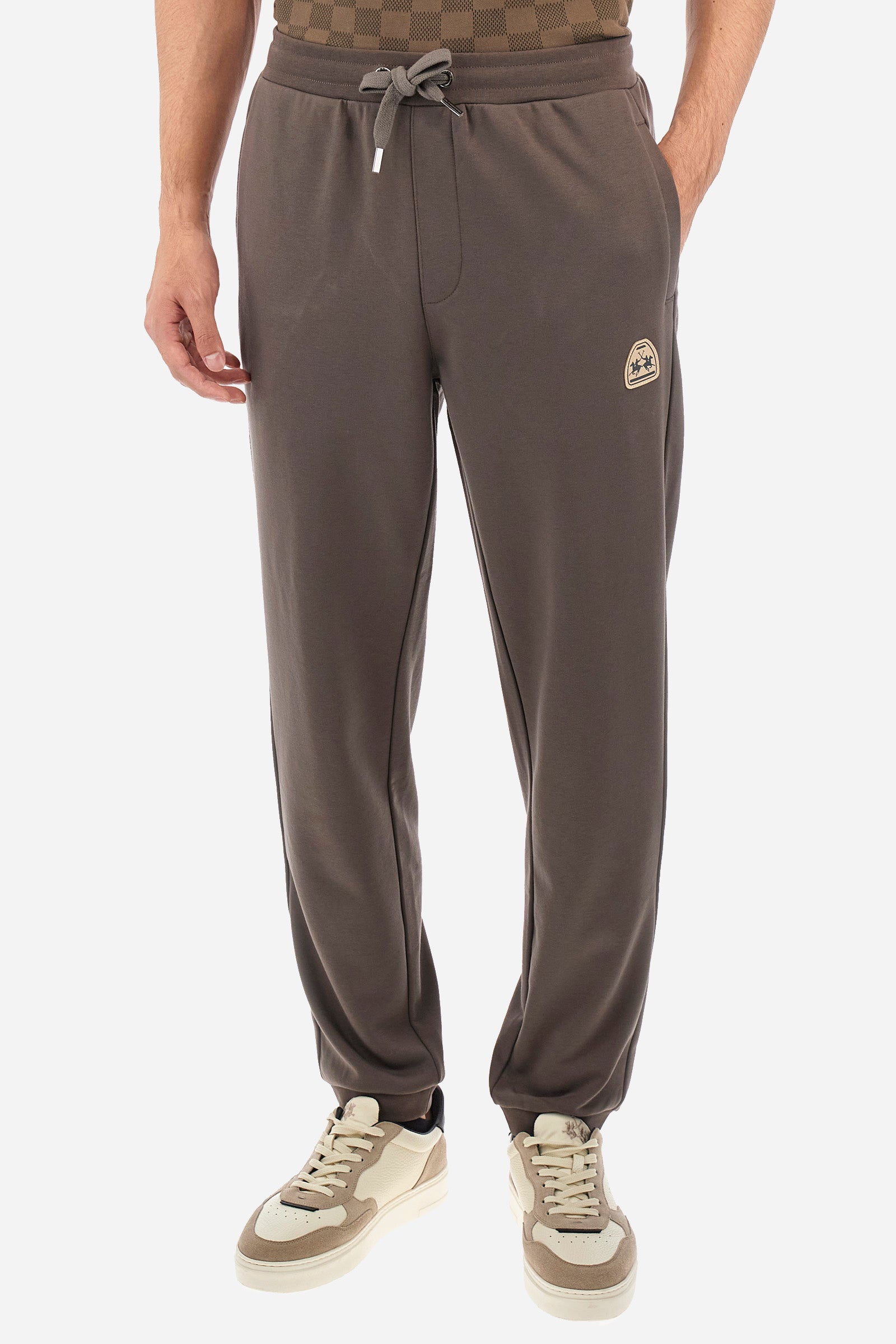 Men's single-colour jogging bottoms in a cotton sweat fabric from the Polo Academy line. With a drawstring waist and double front pocket. Another pocket is present on the back. The logo is present on a patch applied under one of the front pockets. The fit is regular. The model wears a size L. - Bungee Cord