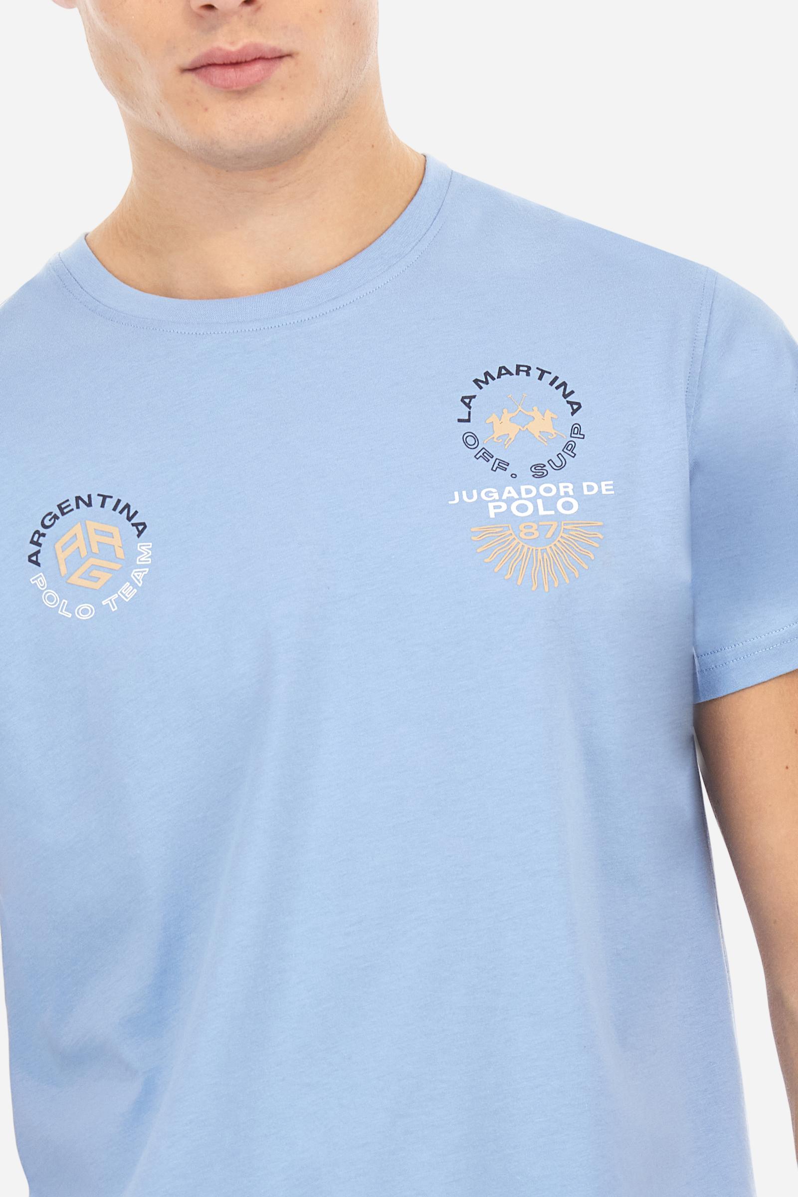 Men's plain cotton jersey T-shirt. Crew-neck model with matching ribbed collar. A contrasting jersey ribbon is applied on the inside of the collar. On the chest we find two graphics, both printed with contrasting colours and gold, that make references to Argentina. On the right sleeve the number 3 is present as a two-tone print with a slightly rubberised appearance. The logo and the La Martina lettering are printed on the chest, left side. Regular fit. The model is wearing a size L. - Vista Blue