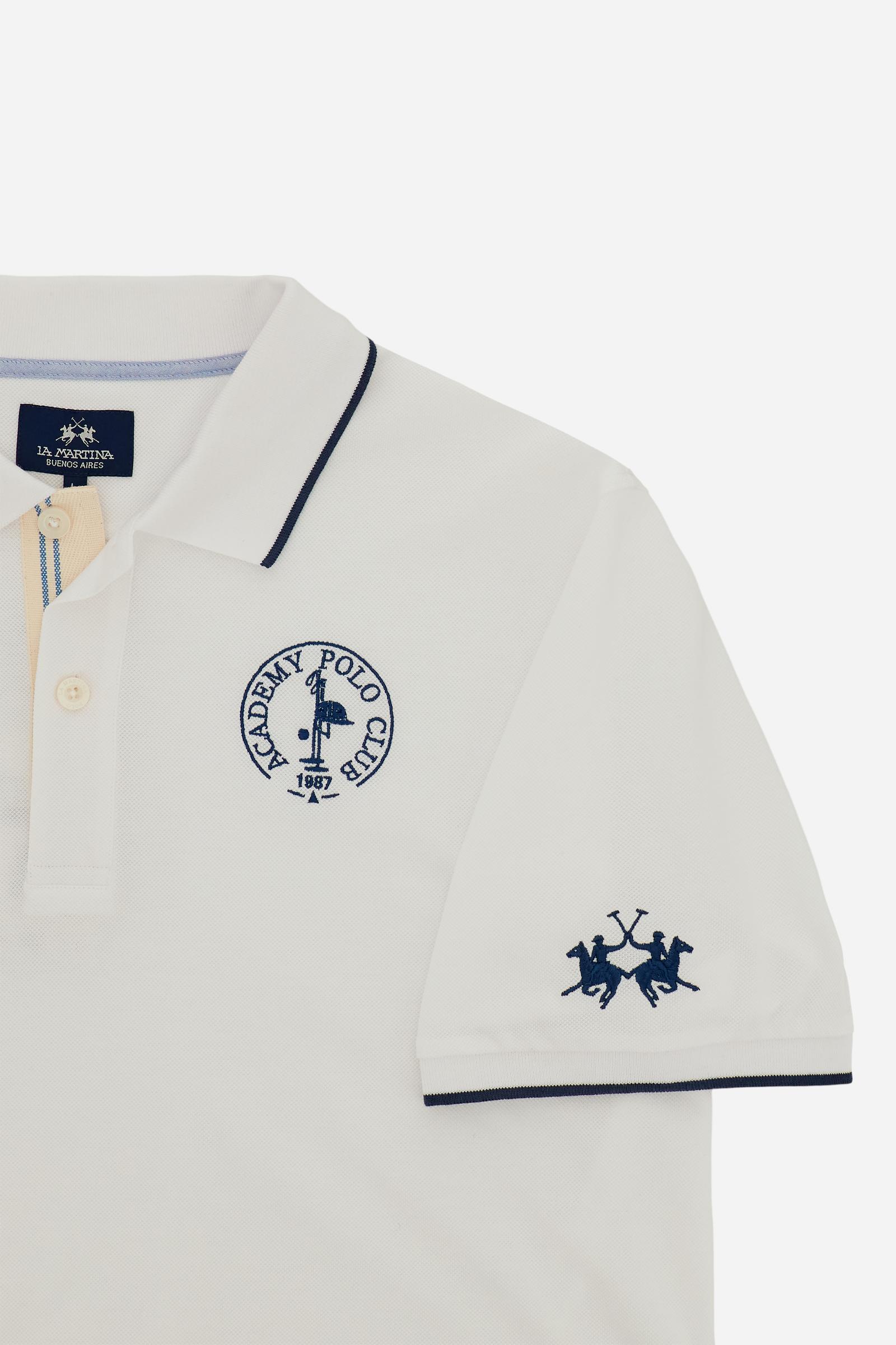Piqué cotton polo with classic collar and contrast details. Graphic embroidery on chest and sleeves, including the “Academy Polo Club” crest. Modern clean fit. - Optic White