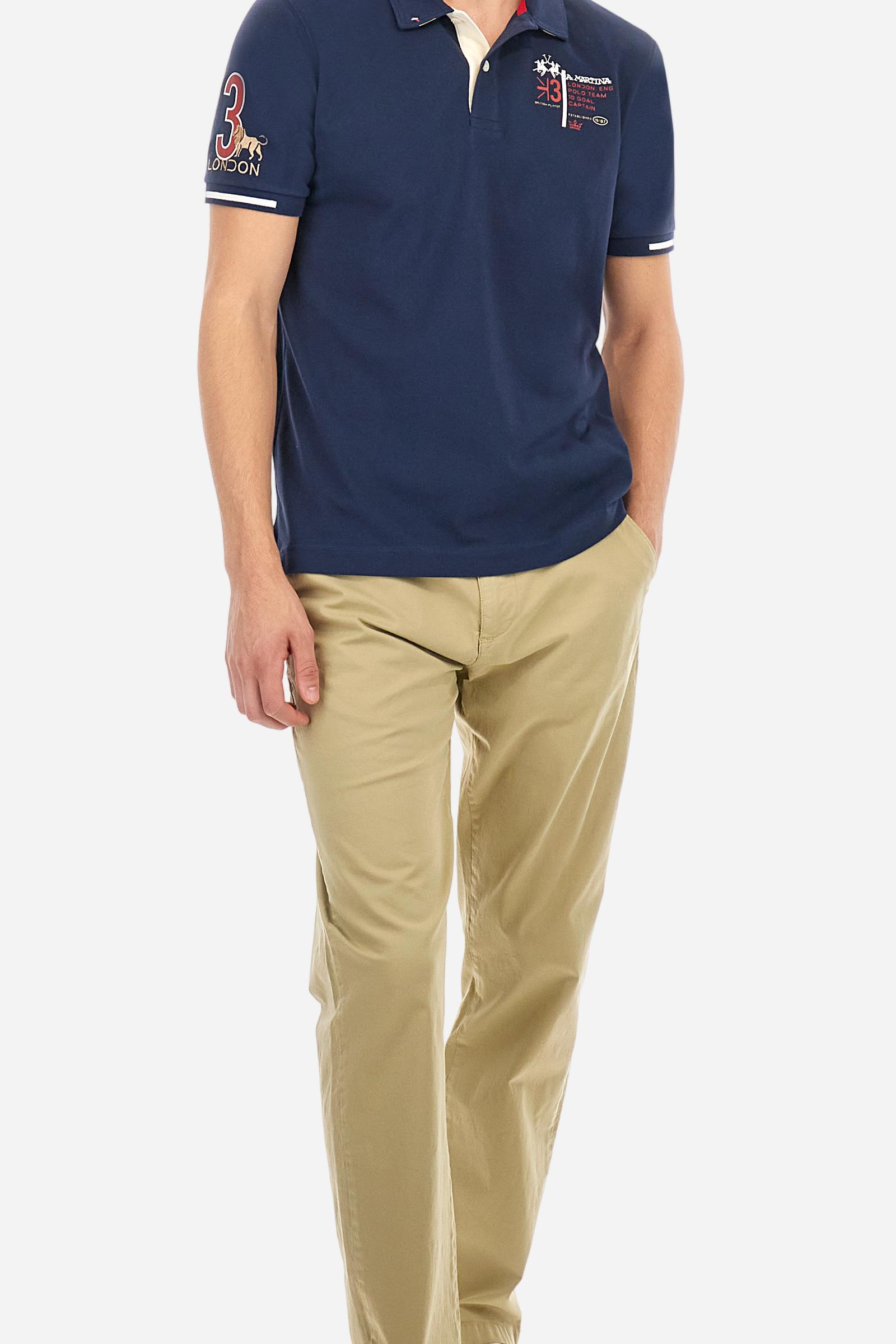 Short-sleeved, single-colour men's polo shirt made of stretch cotton piqué. Fastens with two buttons and internal opening, button side, in contrasting fabric. Ribbed collar and cuffs. The cuffs feature an inlaid detail in a contrasting colour. The graphics on the chest and back are made with mixed techniques: printing and embroidery. The logo is embroidered on the chest, left side. The fit is regular. The model is wearing a size L. - Navy