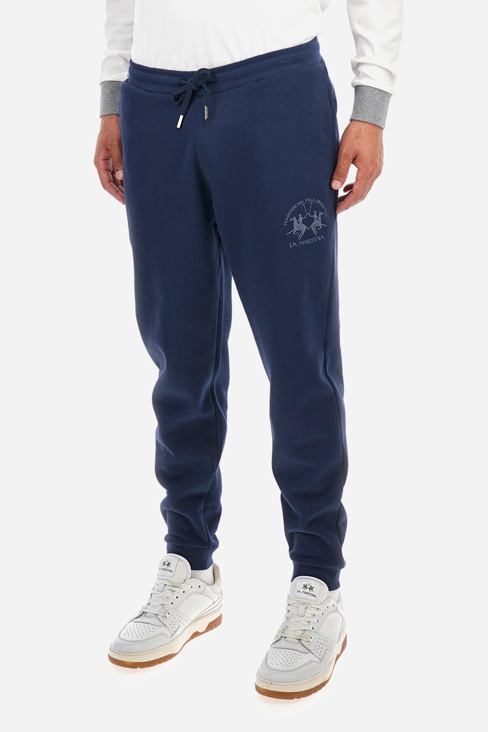 Men's plain jogging bottoms, made from 100% cotton. Drawstring waist and double front pockets. There is an additional pocket on the back. The logo is embroidered on the front. Regular fit. The model is wearing a size L. - Navy