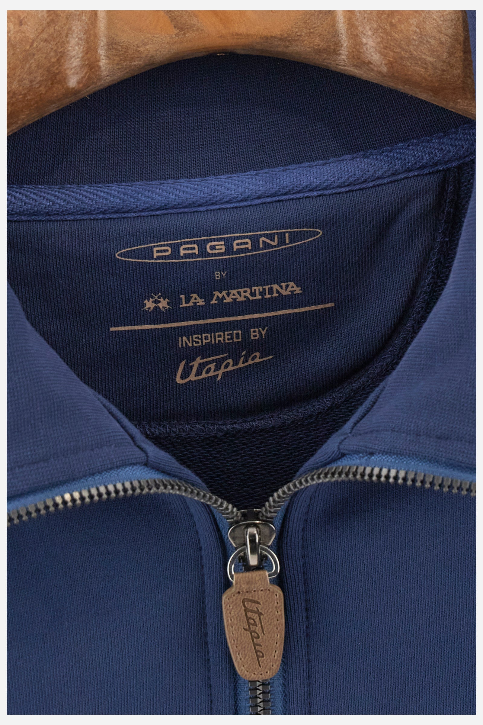 Single-colour long-sleeved men's sweatshirt with full zip fastening from the line in collaboration with Pagani. Made of 100% cotton. Mock neck, ribbed waistband and cuffs. Double back pocket. On the sides the garment has a different texture from the main part. There is lettering on the front, while a plate featuring the La Martina logo and the Pagani logo is sewn on the back. The fit is regular. The model wears a size L. - Ensign Blue