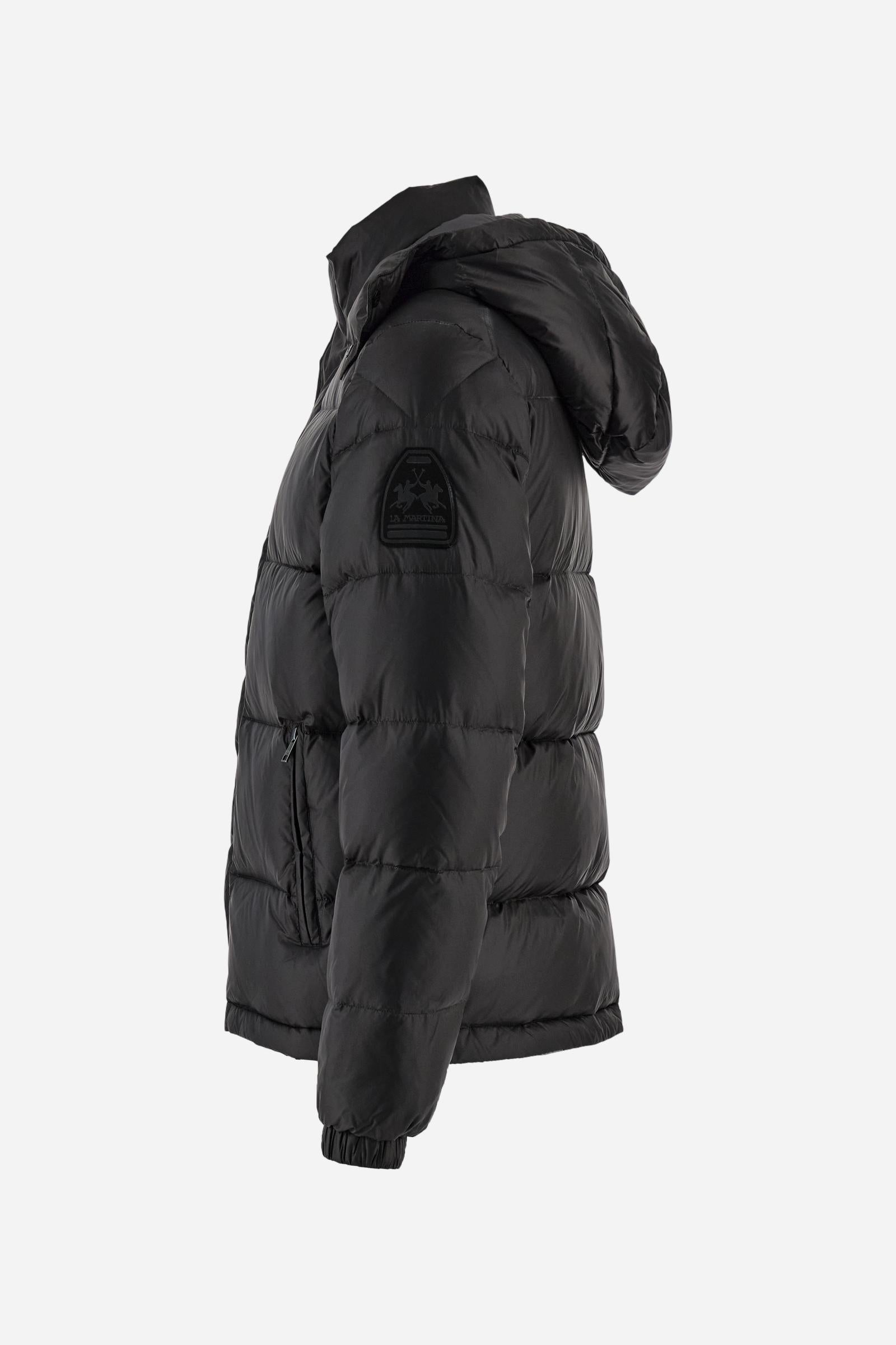 Men’s padded bomber jacket with detachable hood. Made of solid iridescent nylon with contrast lining. Equipped with two practical inner braces for extra comfort. Double customized zip front closure with inner placket featuring contrast Polo Player print, closed with metal snap buttons. Two vertical zipped pockets on the front. Hood with contrast lining and adjustable elastic drawstring. Bold Polo Player graphics printed inside. Regular fit for comfortable movement without bulk. Model wears size L. - Black