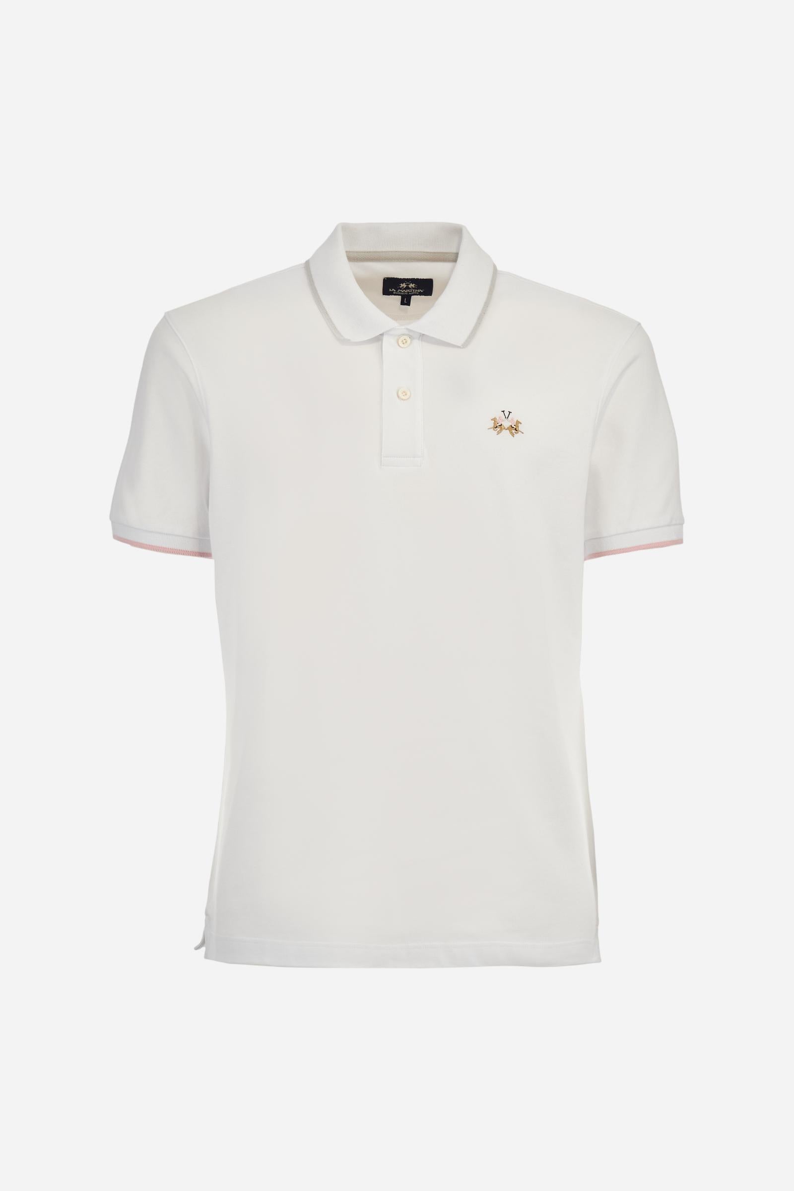 Short-sleeved, single-colour men's polo shirt made of stretch cotton piqué. Fastens with two buttons. The collar and cuffs are ribbed, and there is a colour-contrasting trim at the bottom of the collar. Inside the collar there is a grosgrain ribbon of a different shade. The logo is embroidered on the chest in a contrasting colour. The fit is slim. The model is wearing a size L. - Optic White