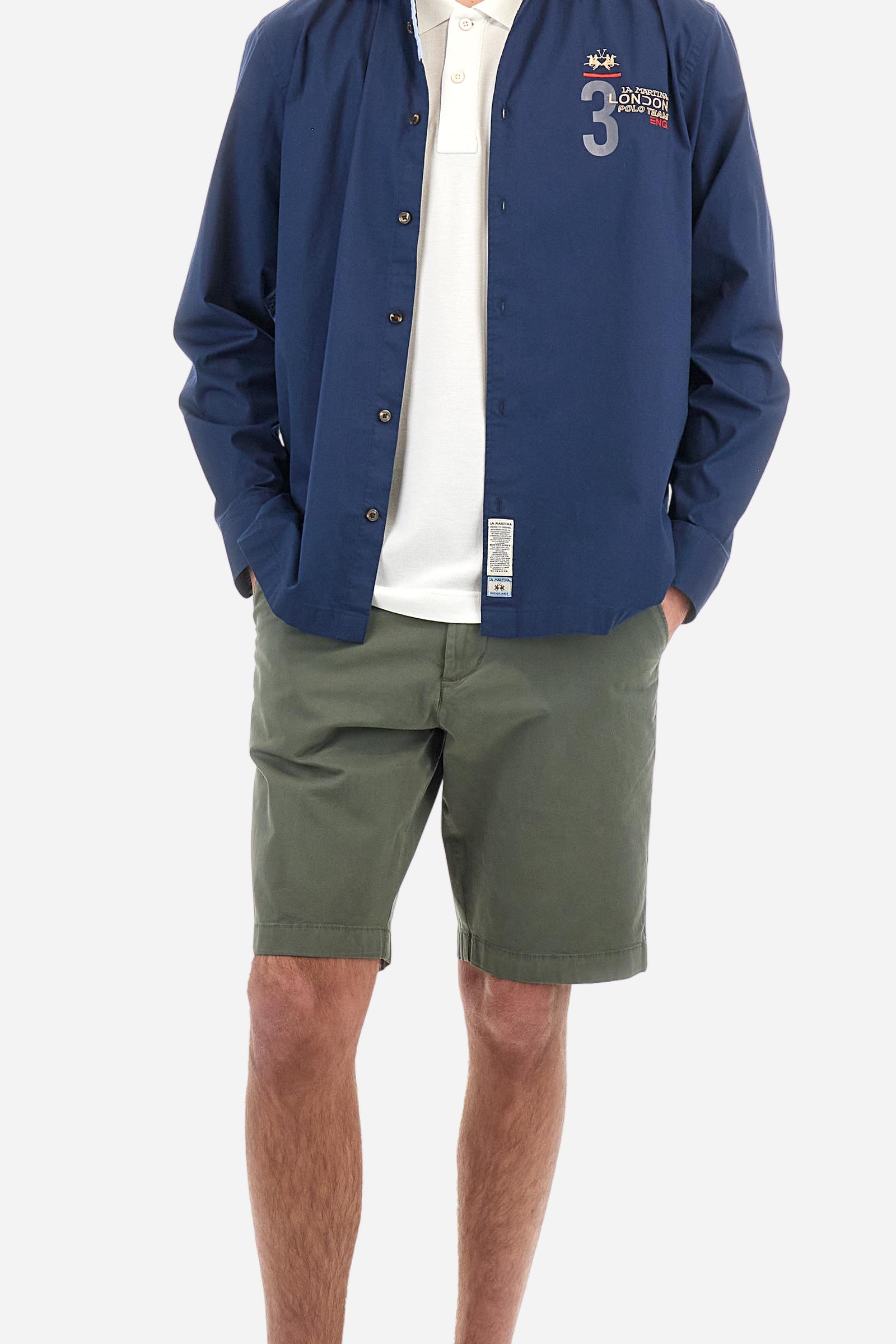 Men's single-colour long-sleeved shirt, made from 100% cotton poplin. Spread collar. Contrasting printed fabric details on the inside of the collar and opening. The numbers on the chest and back graphics are rubberised prints, while the rest of the graphics are embroidered. The logo and La Martina lettering is embroidered on the left chest. The fit is regular. The model is wearing a size L. - Navy