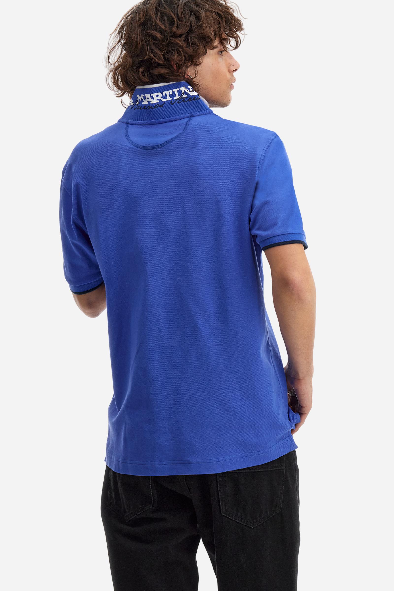 Short-sleeved, single-colour men's polo shirt made of stretch cotton piqué. Fastens with two buttons. The collar and cuffs are ribbed, and there is a colour-contrasting trim at the bottom of the collar. Inside the collar there is a grosgrain ribbon of a different shade. The logo is embroidered on the chest in a contrasting colour. The fit is slim. The model is wearing a size L. - Dazzling Blue